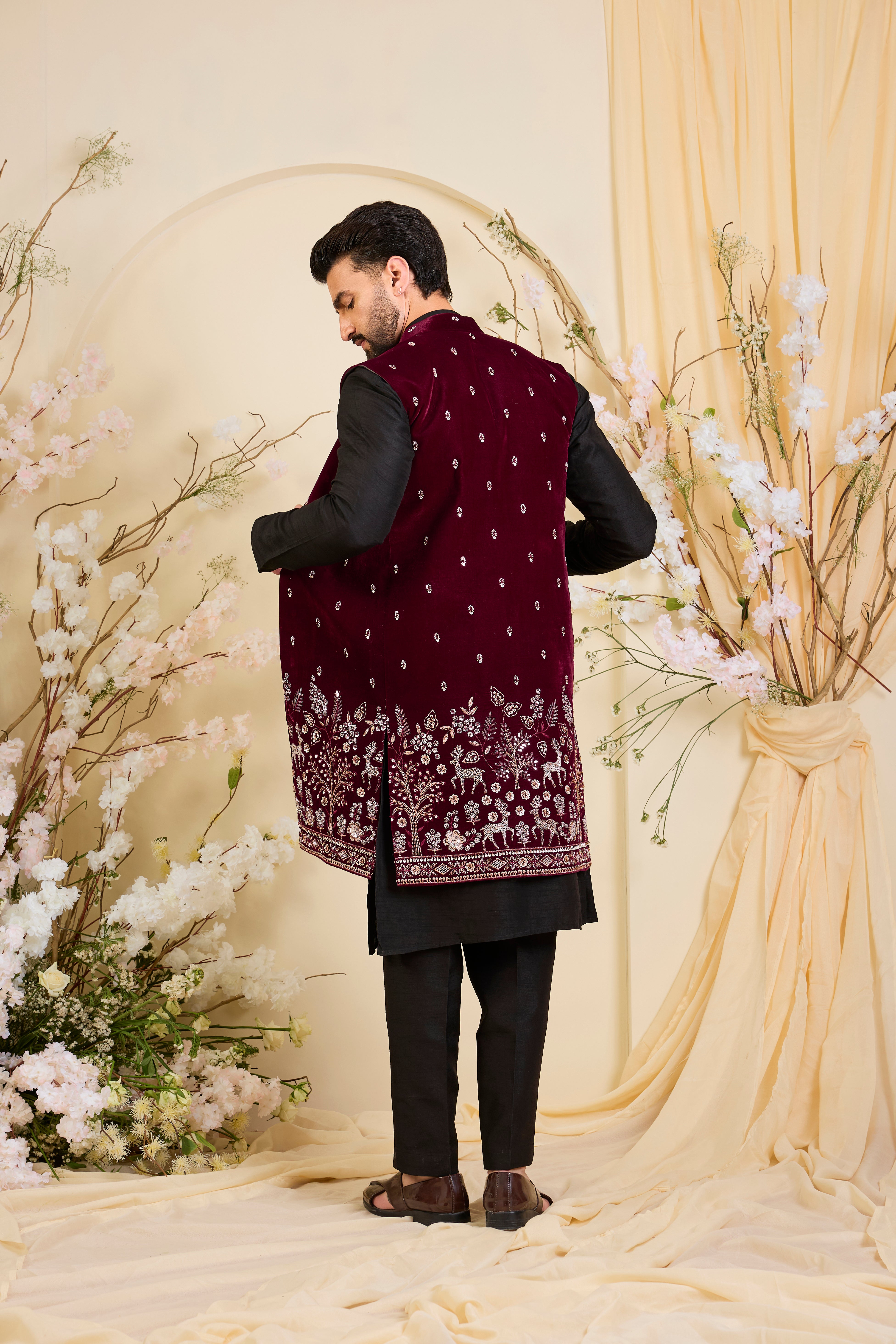 An opulent maroon long open , intricately hand-embroidered with dense cut dana work and elaborate flora-fauna motifs, exuding regal depth and grand sophistication.