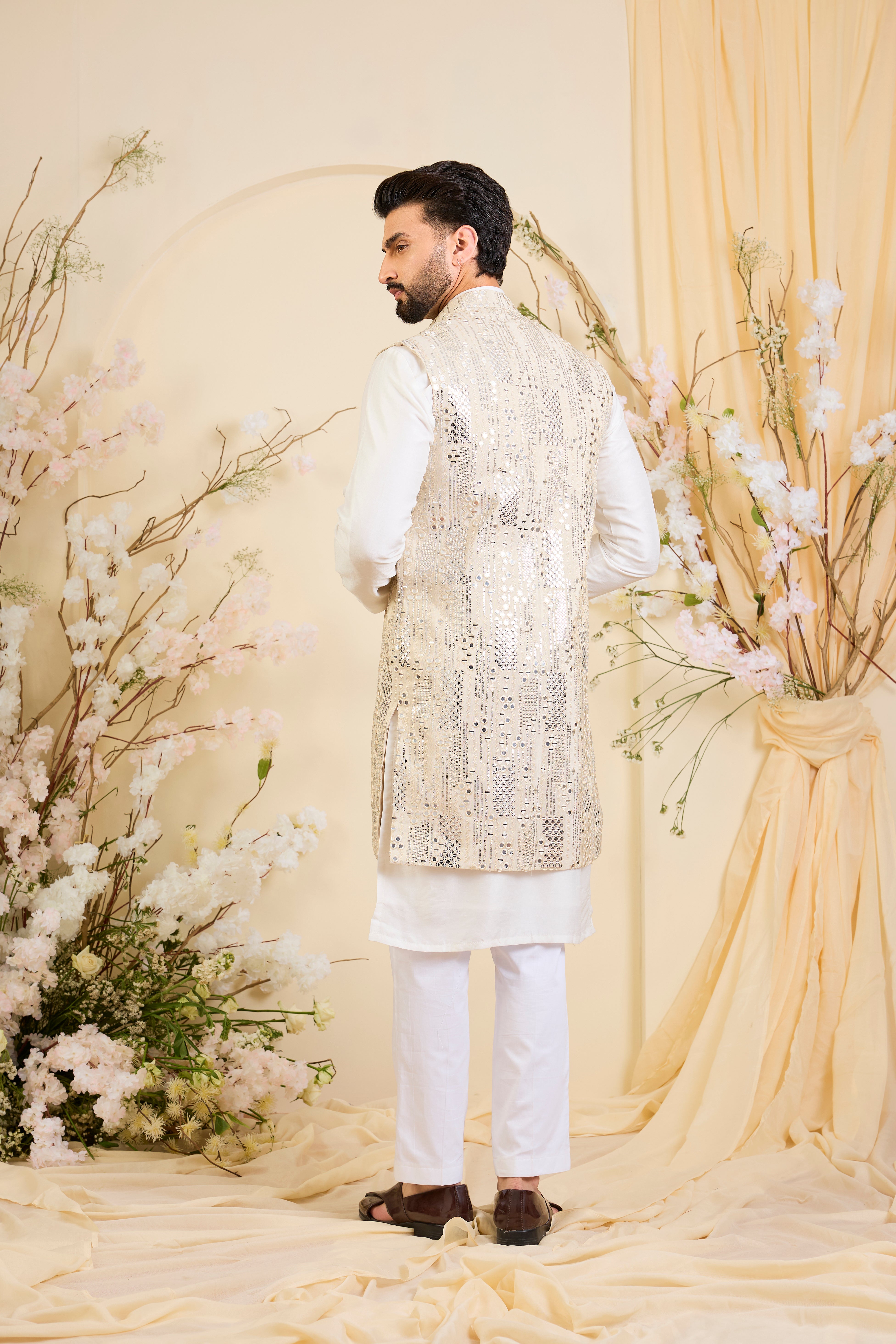 Crafted in luminous tissue, this long open jacket is intricately detailed with sequin mirrorwork, creating a refined illusion of traditional mirrors.