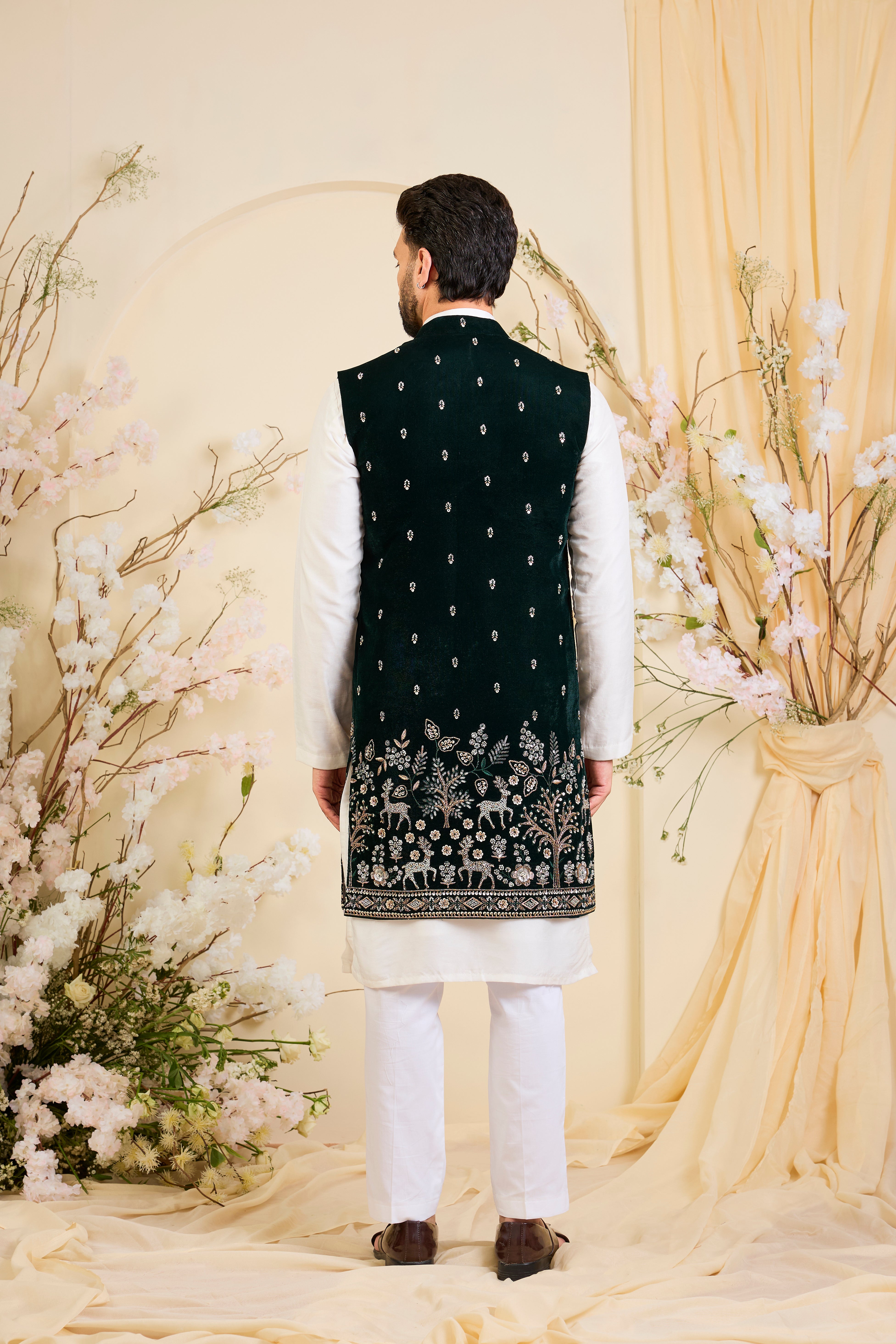 An opulent bottle green long open , intricately hand-embroidered with dense cut dana work and elaborate flora-fauna motifs, exuding regal depth and grand sophistication.
