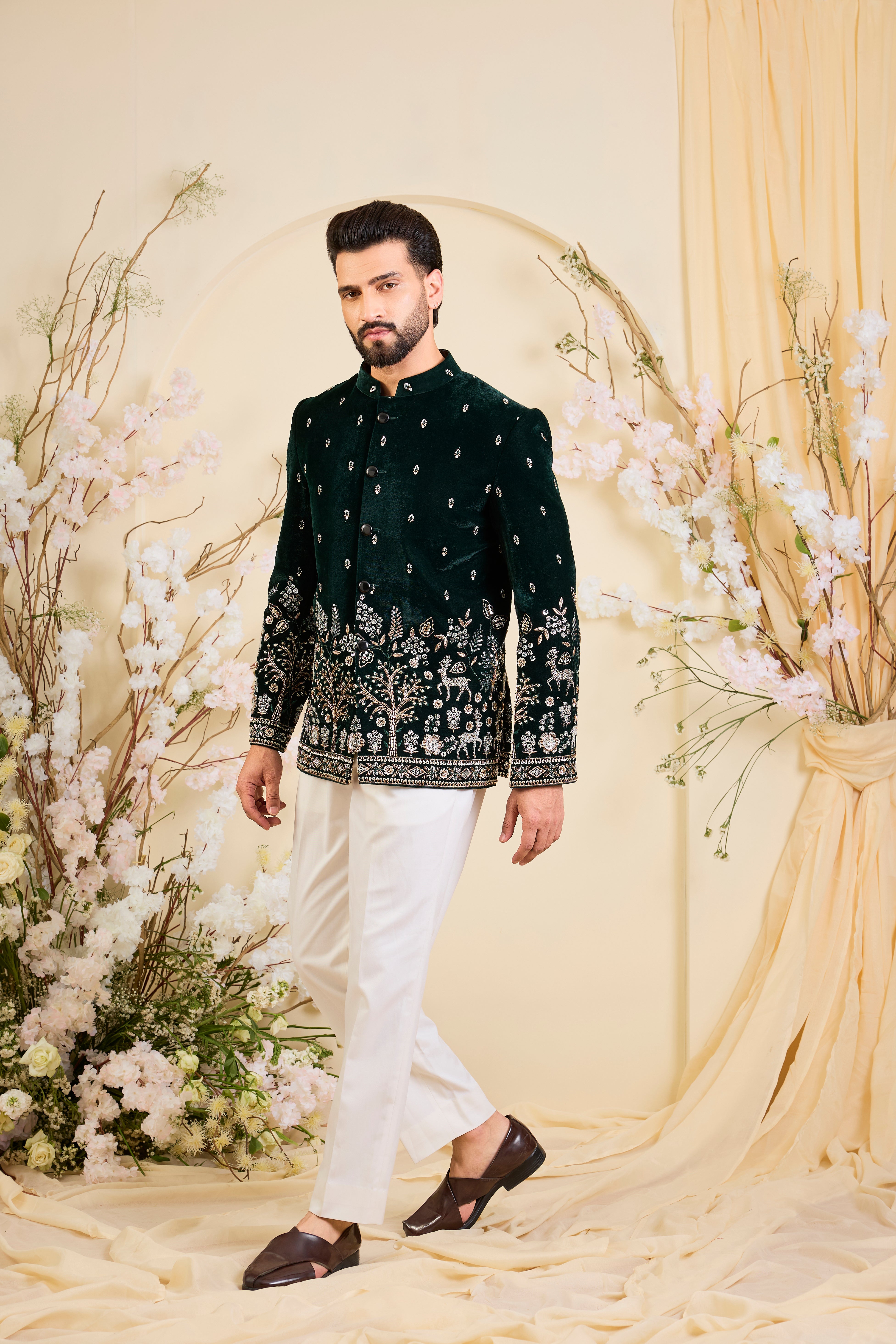 An opulent bottle green bandgala , intricately hand-embroidered with dense cut dana work and elaborate flora-fauna motifs, exuding regal depth and grand sophistication.