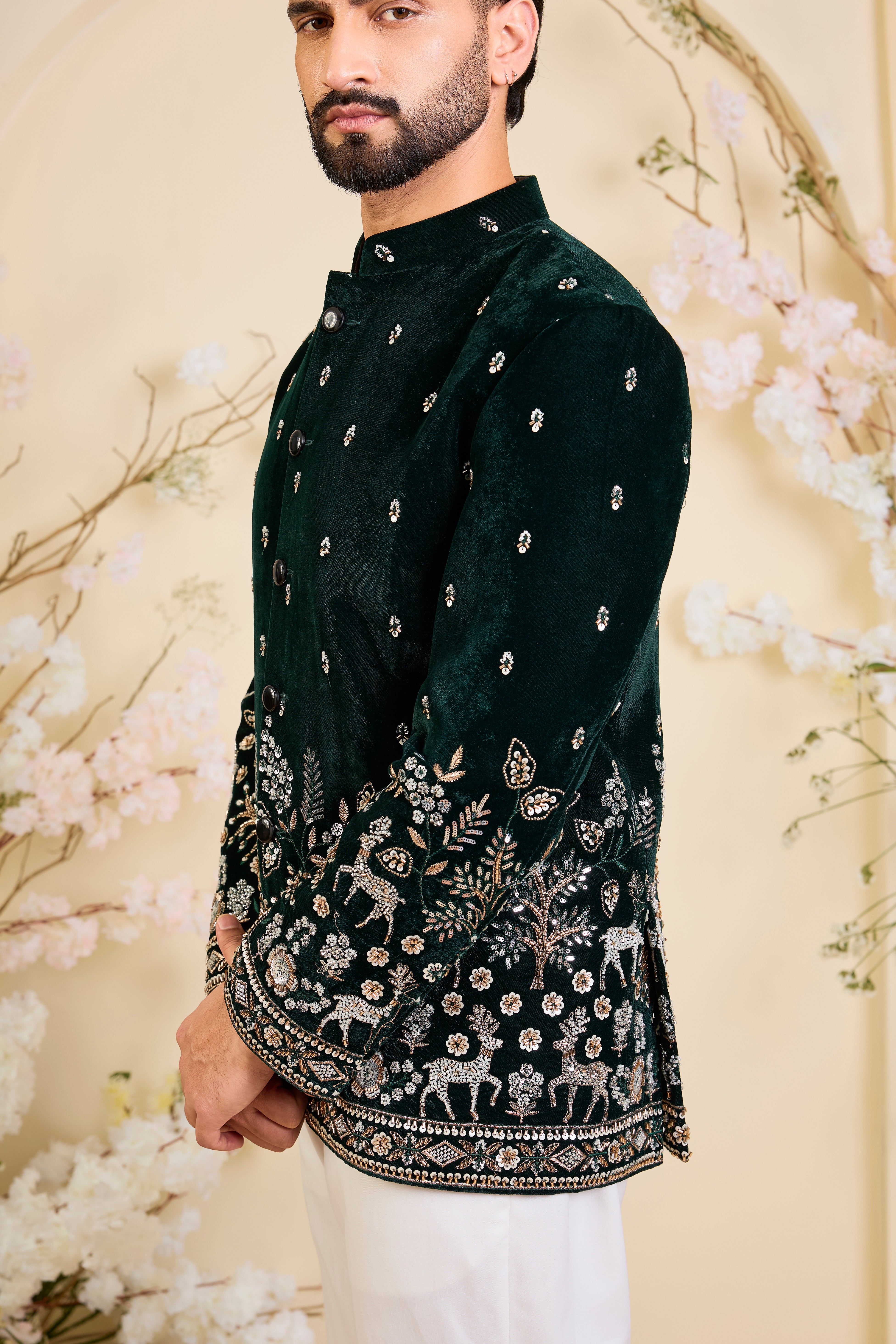An opulent bottle green bandgala , intricately hand-embroidered with dense cut dana work and elaborate flora-fauna motifs, exuding regal depth and grand sophistication.