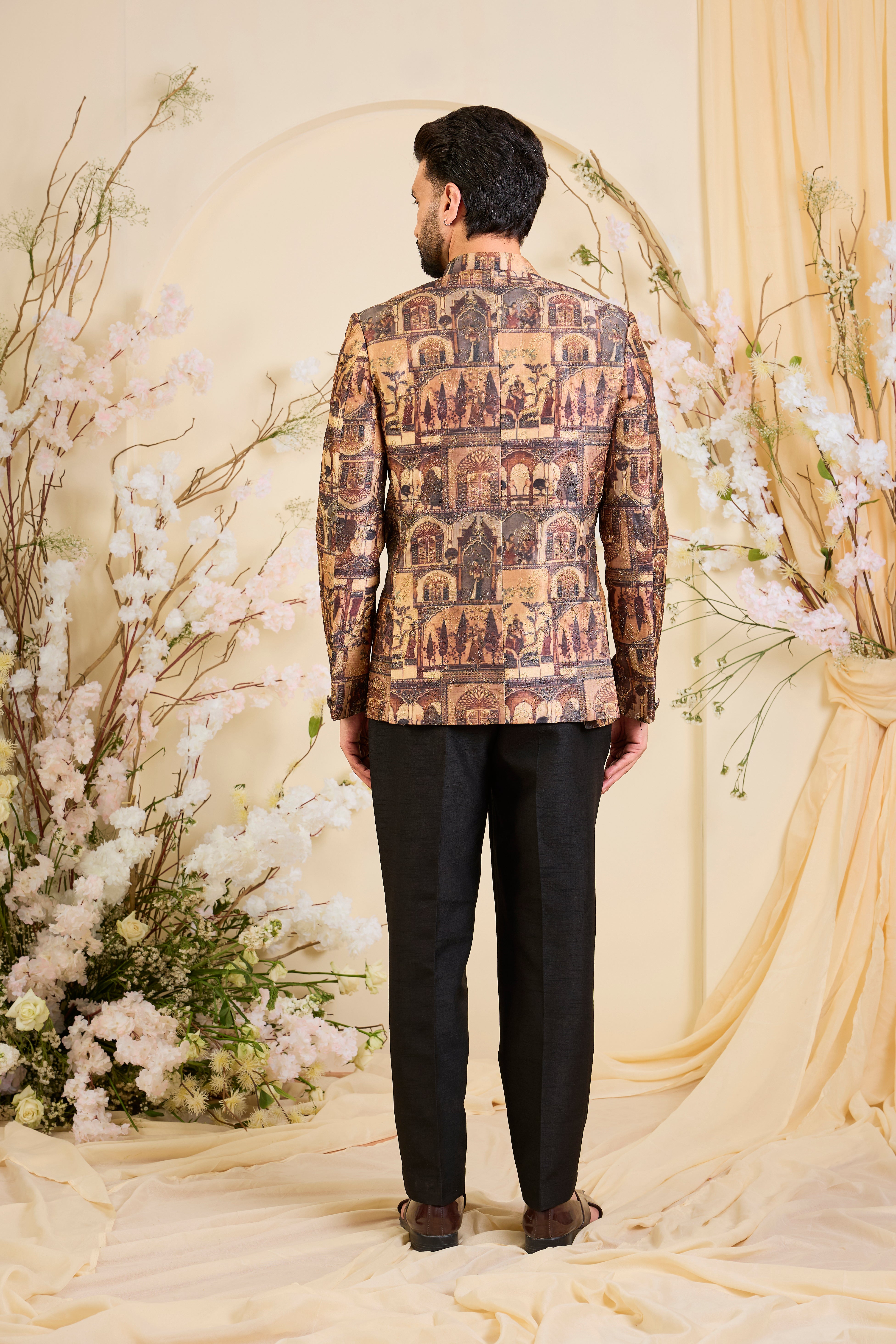 Rendered in a deep earthy brown, this bandgala unfolds like a living canvas of Mughal grandeur, adorned with intricately illustrated royal figures and courtly scenes.