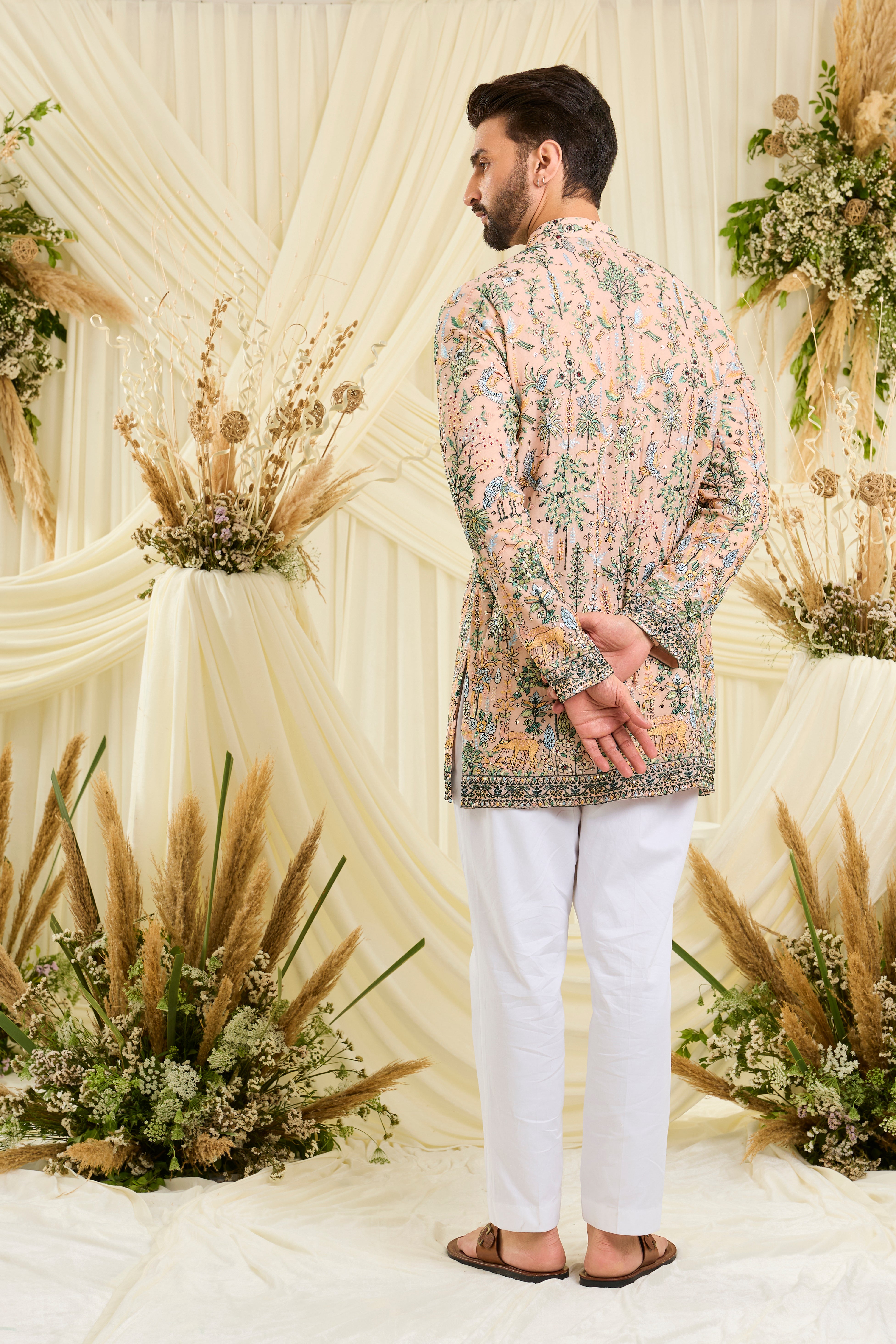 Peach short kurta with intricate flora-fauna embroidery, multicolour threadwork, and delicate sequins for a fresh, luxe festive statement.