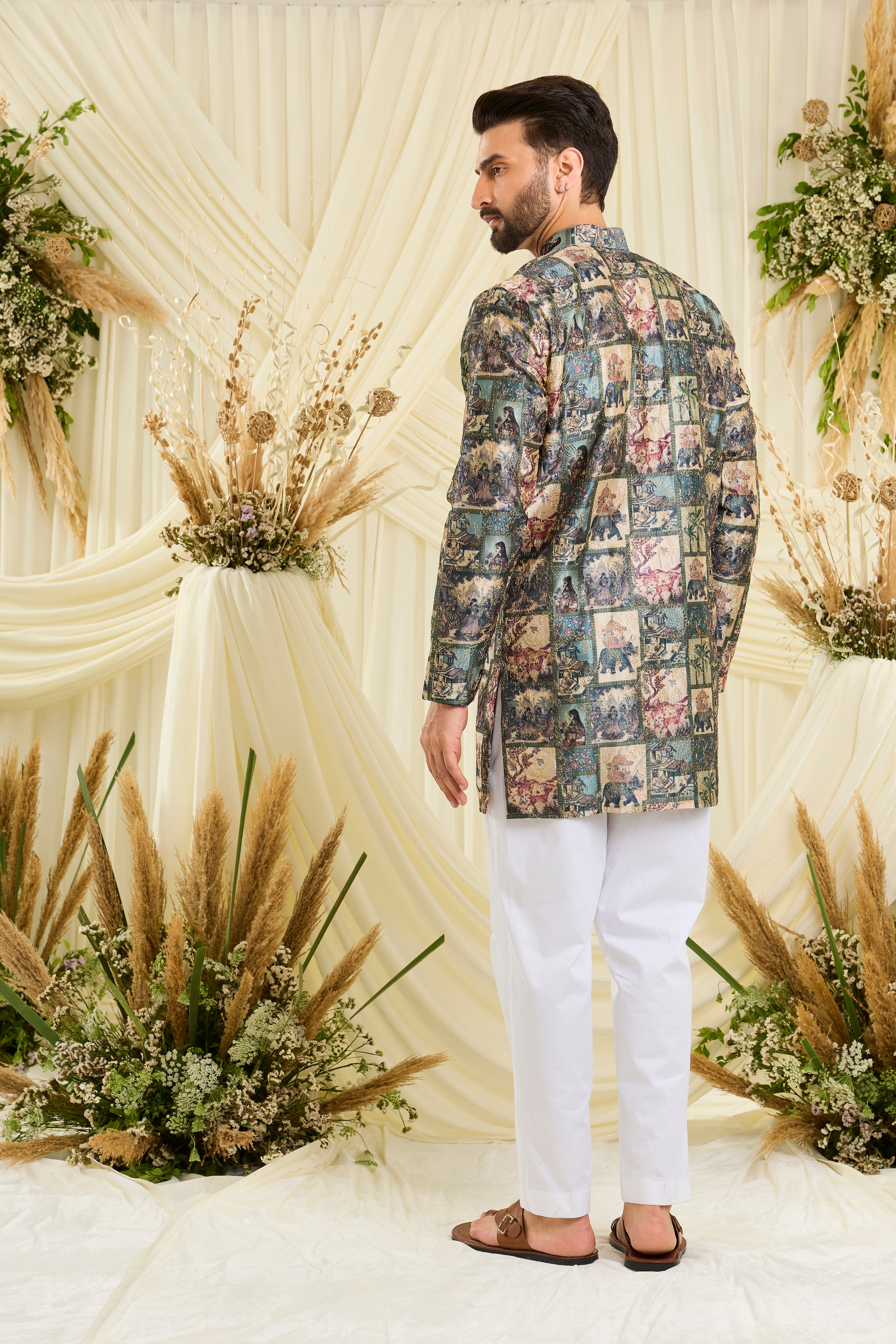 Green short kurta with multicoloured Mughal-era prints, historic motifs,  and intricate aari embroidery for a bold, artistic statement.