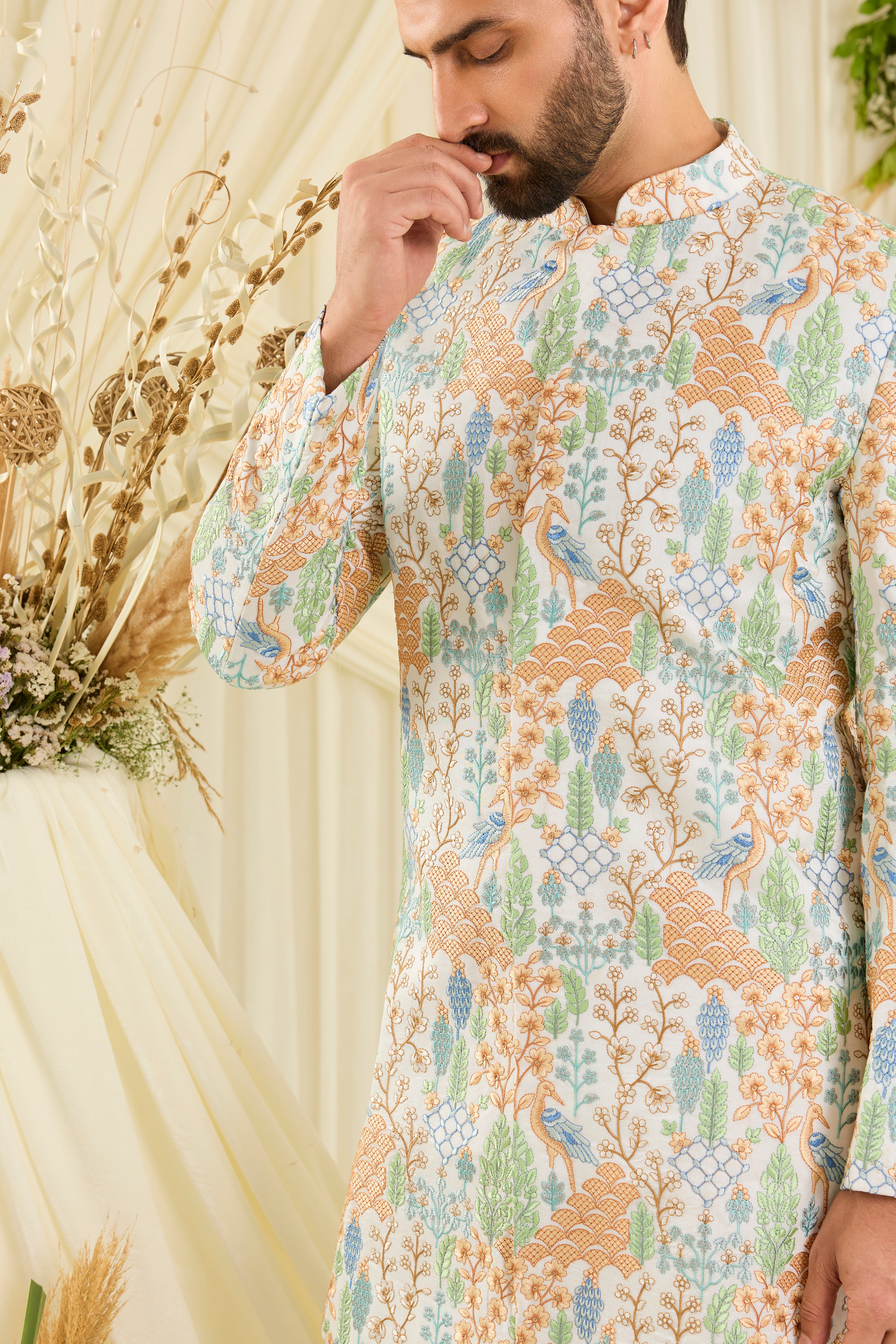Ivory short sherwani with heavy flora-fauna embroidery, multicolour threadwork, and delicate sequins for a richly detailed, luxe statement.