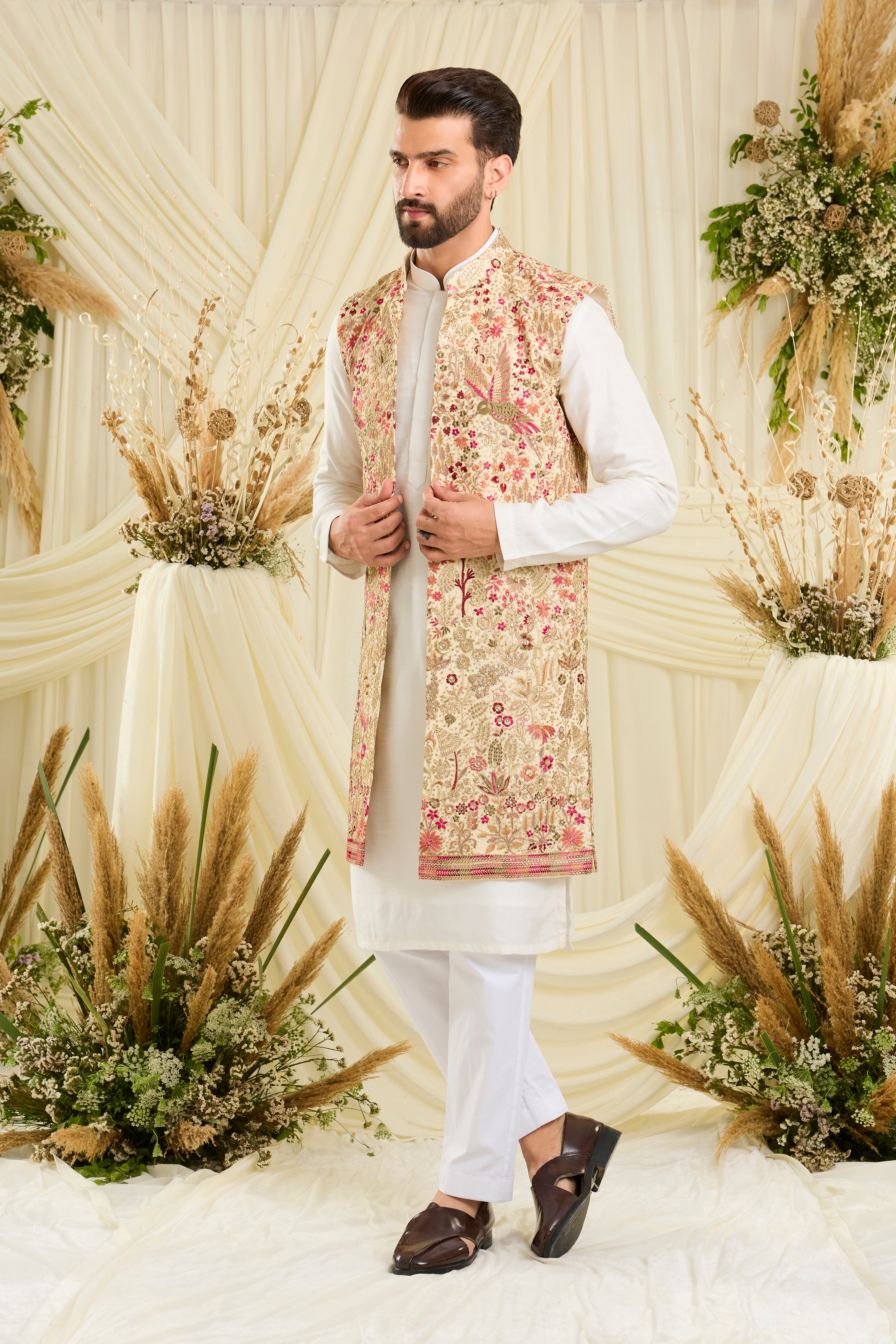 Cream-gold long open jacket with flora-fauna embroidery, multicolour threadwork, and delicate sequins for a rich, elevated couture statement.