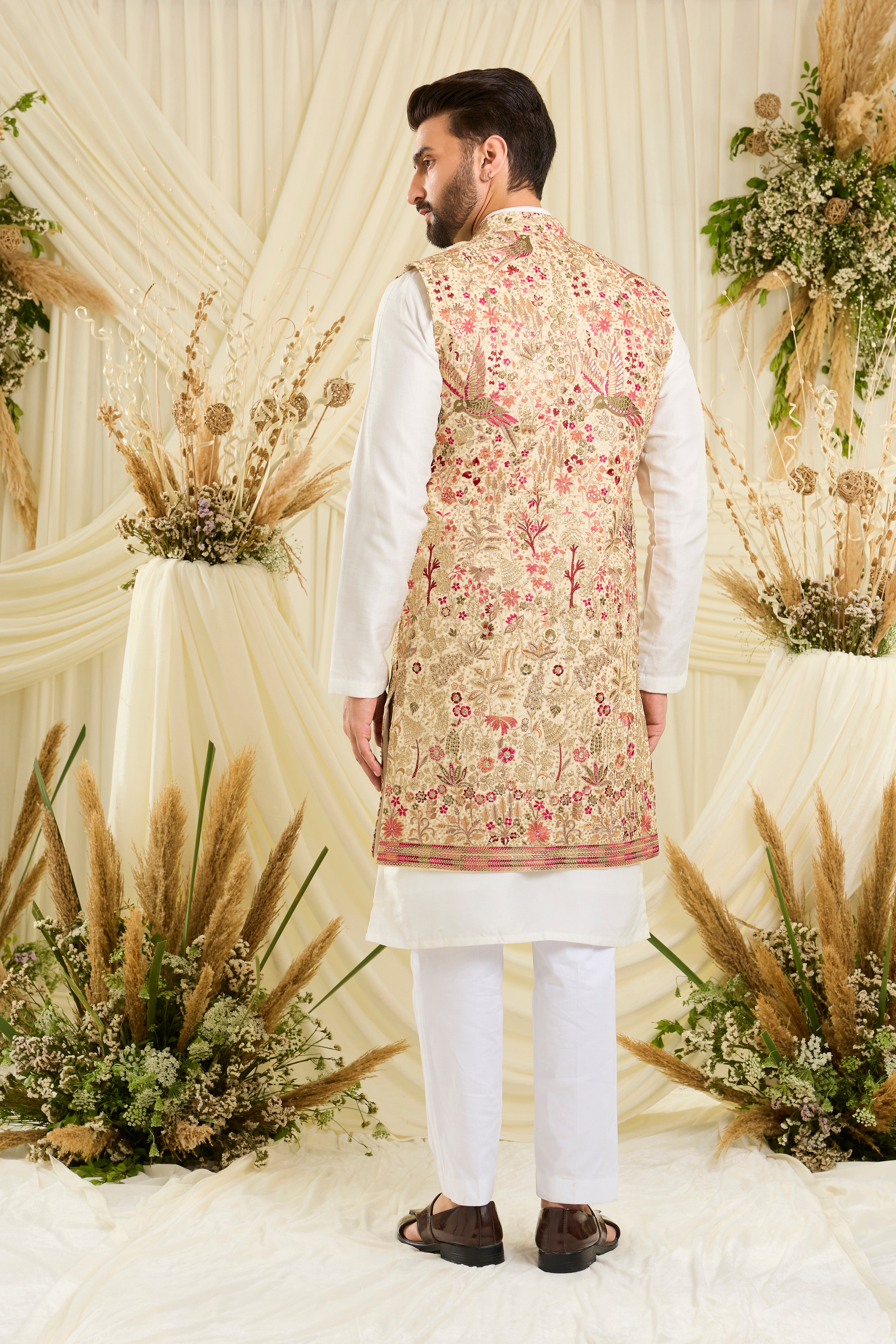 Cream-gold long open jacket with flora-fauna embroidery, multicolour threadwork, and delicate sequins for a rich, elevated couture statement.