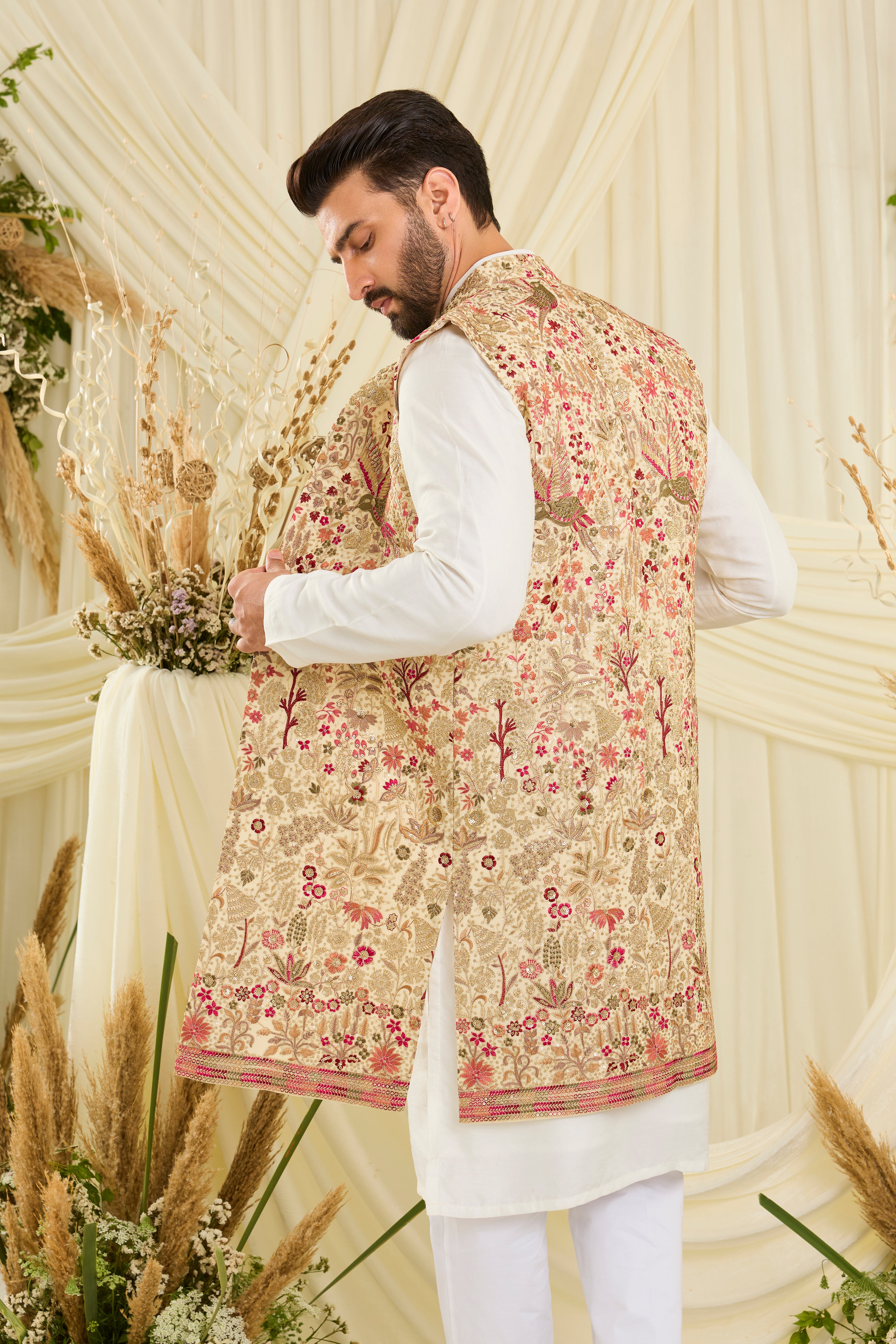 Cream-gold long open jacket with flora-fauna embroidery, multicolour threadwork, and delicate sequins for a rich, elevated couture statement.
