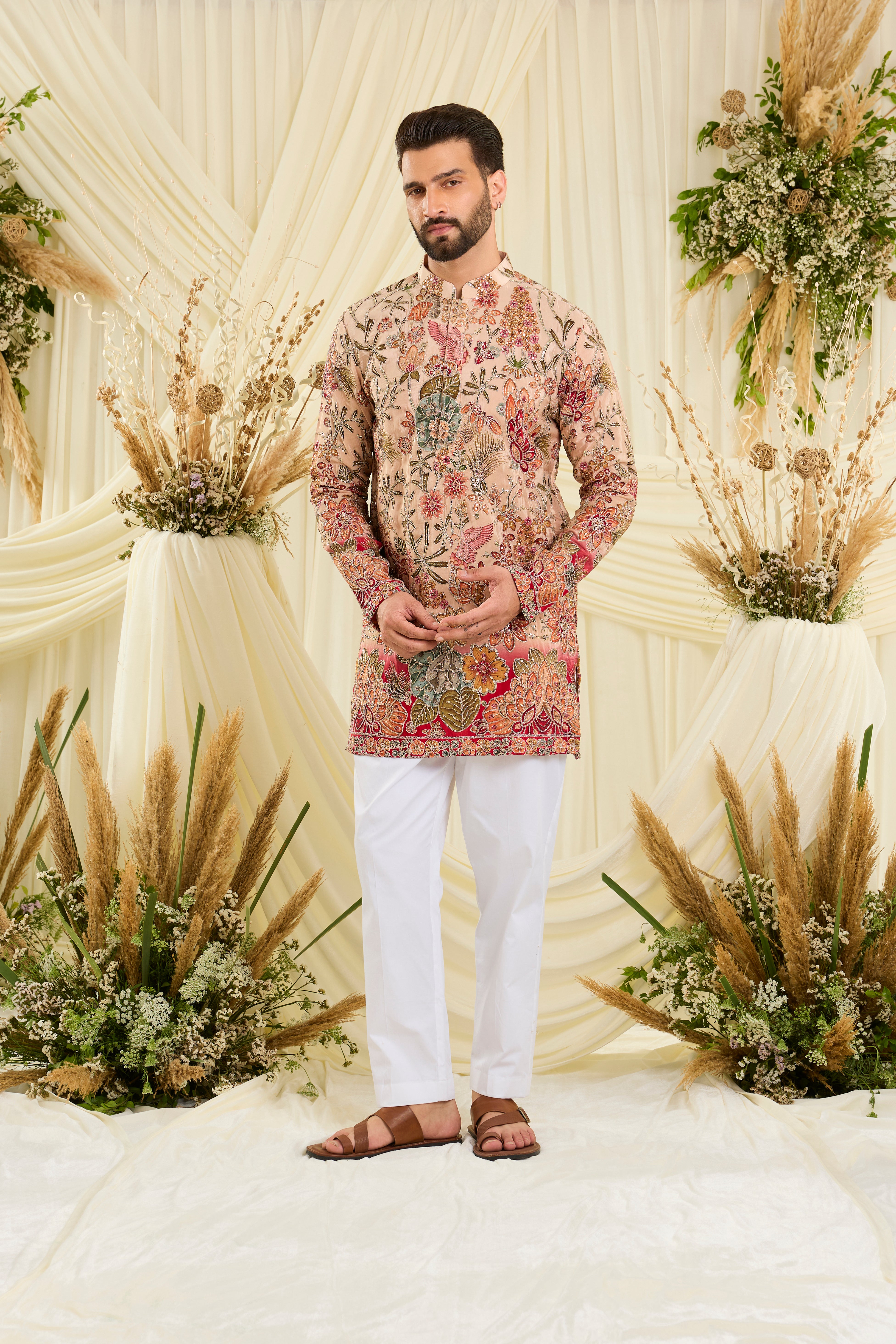 Pastel peach short kurta with intricate floral embroidery, rich zari detailing, and delicate sequins for a refined, luminous festive statement.