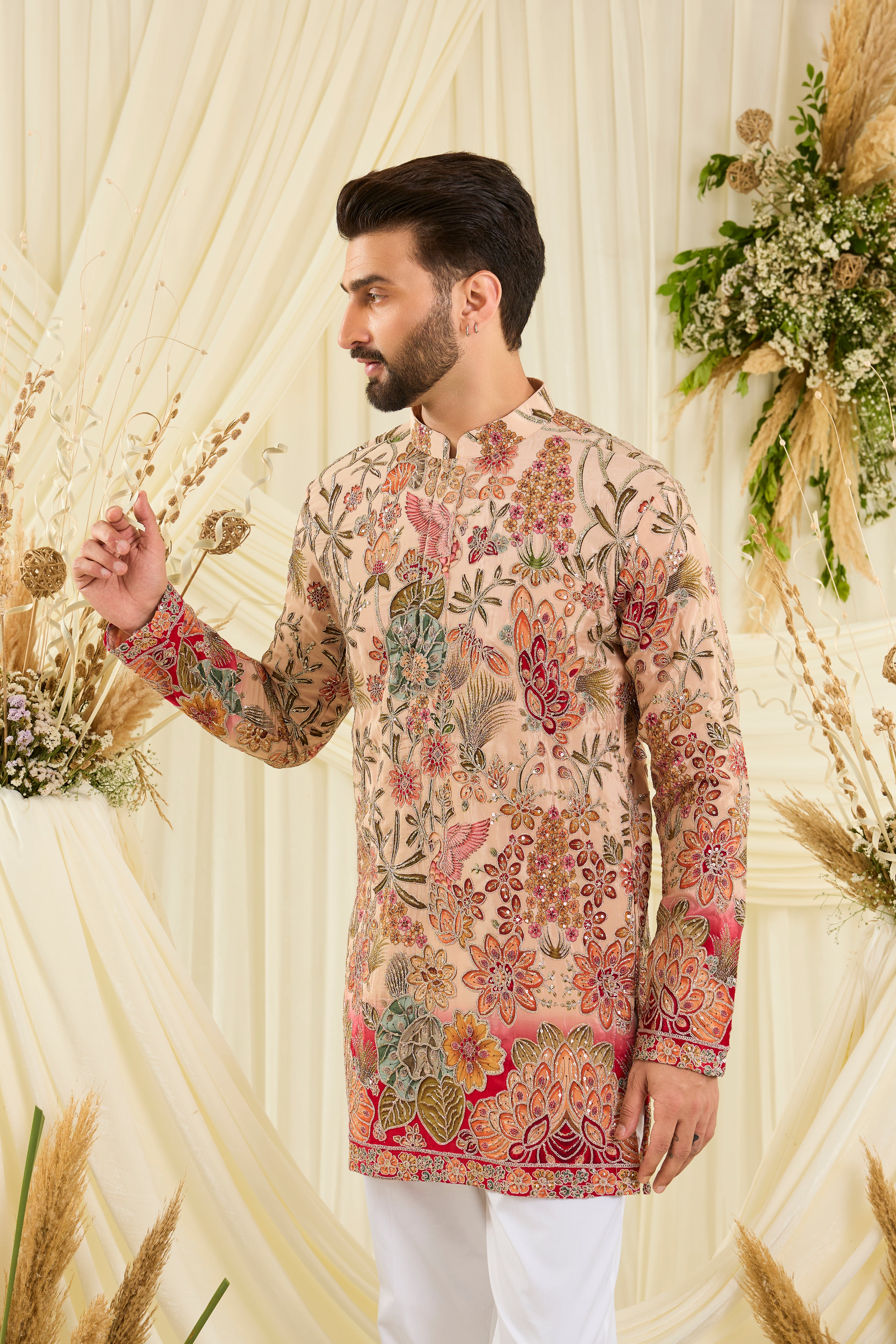 Pastel peach short kurta with intricate floral embroidery, rich zari detailing, and delicate sequins for a refined, luminous festive statement.
