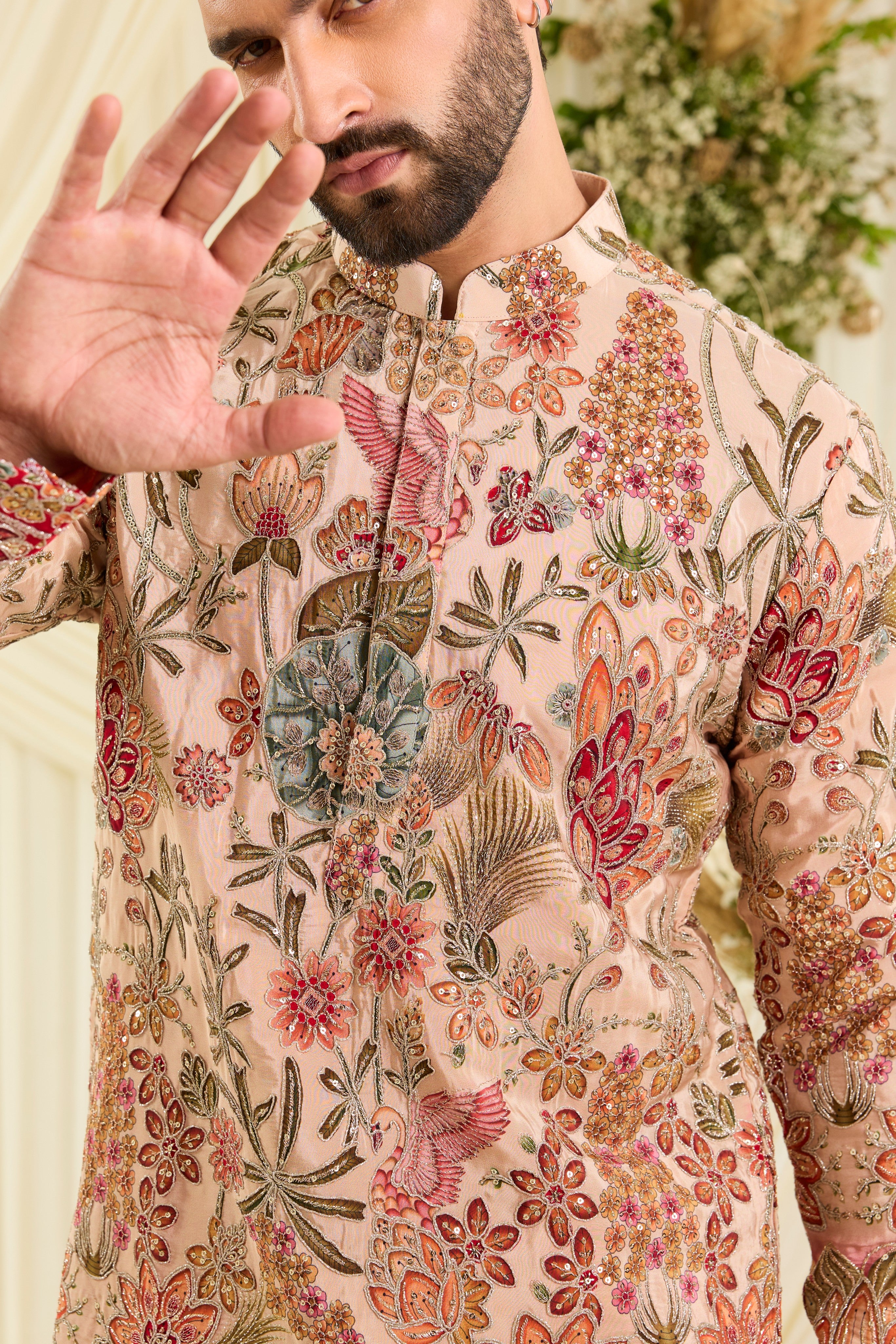 Pastel peach short kurta with intricate floral embroidery, rich zari detailing, and delicate sequins for a refined, luminous festive statement.