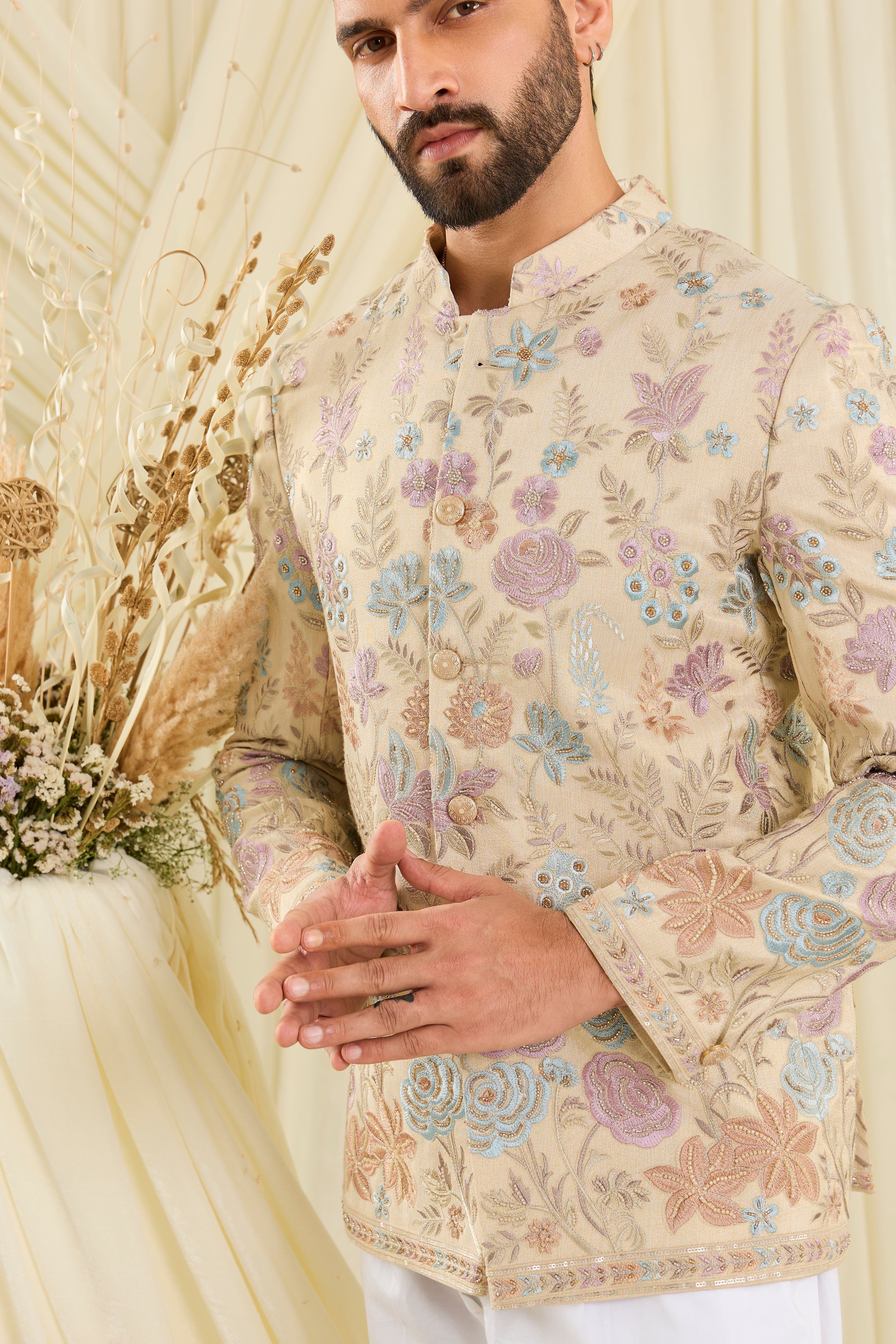Cream-gold bandhgala with floral embroidery, multicolour threadwork, and cut dana detailing — regal, luminous, and effortlessly sophisticated.