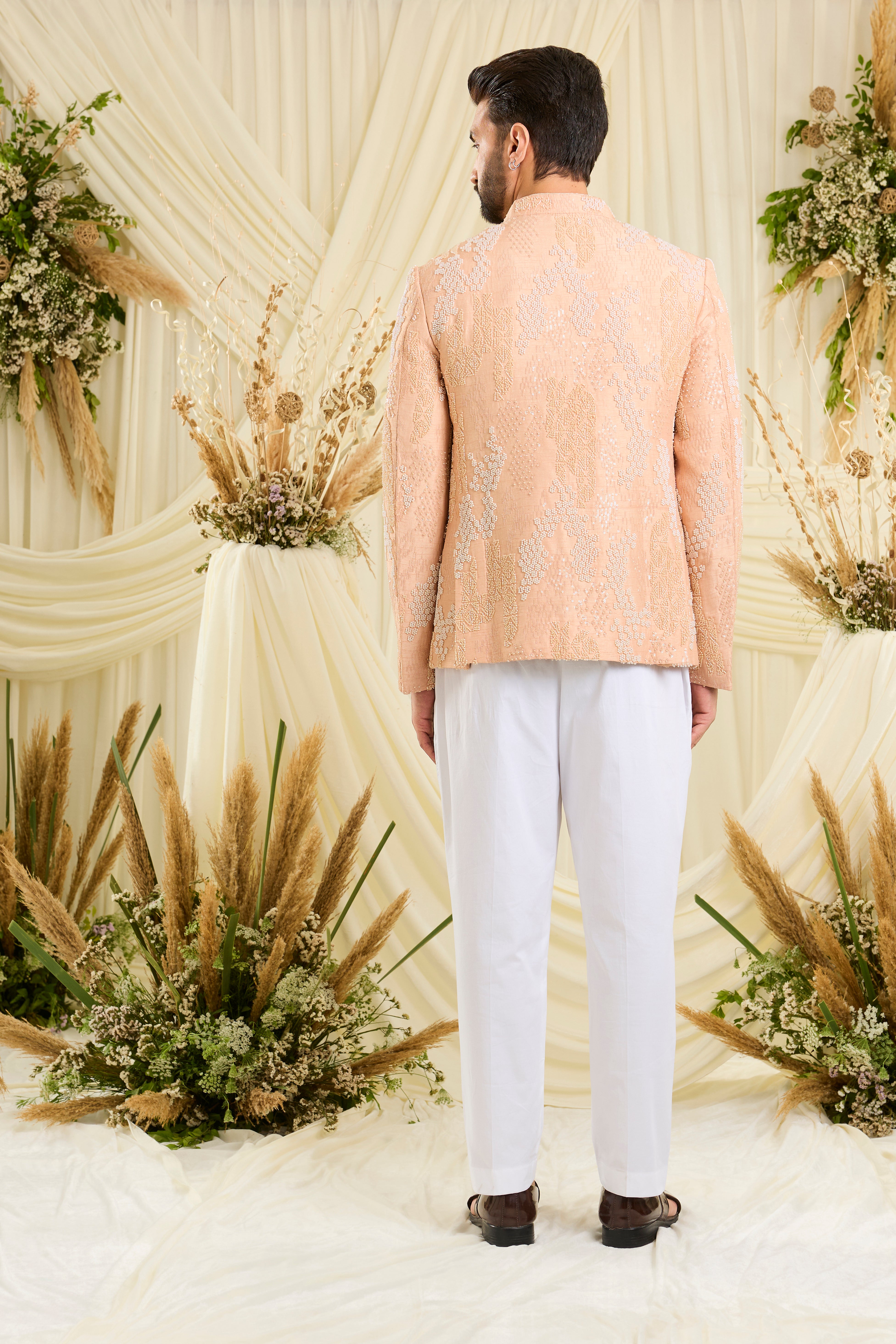 Peach bandhgala with hand embroidery, tonal cut dana, and ivory beads — impeccably regal, refined, and royally luxurious.