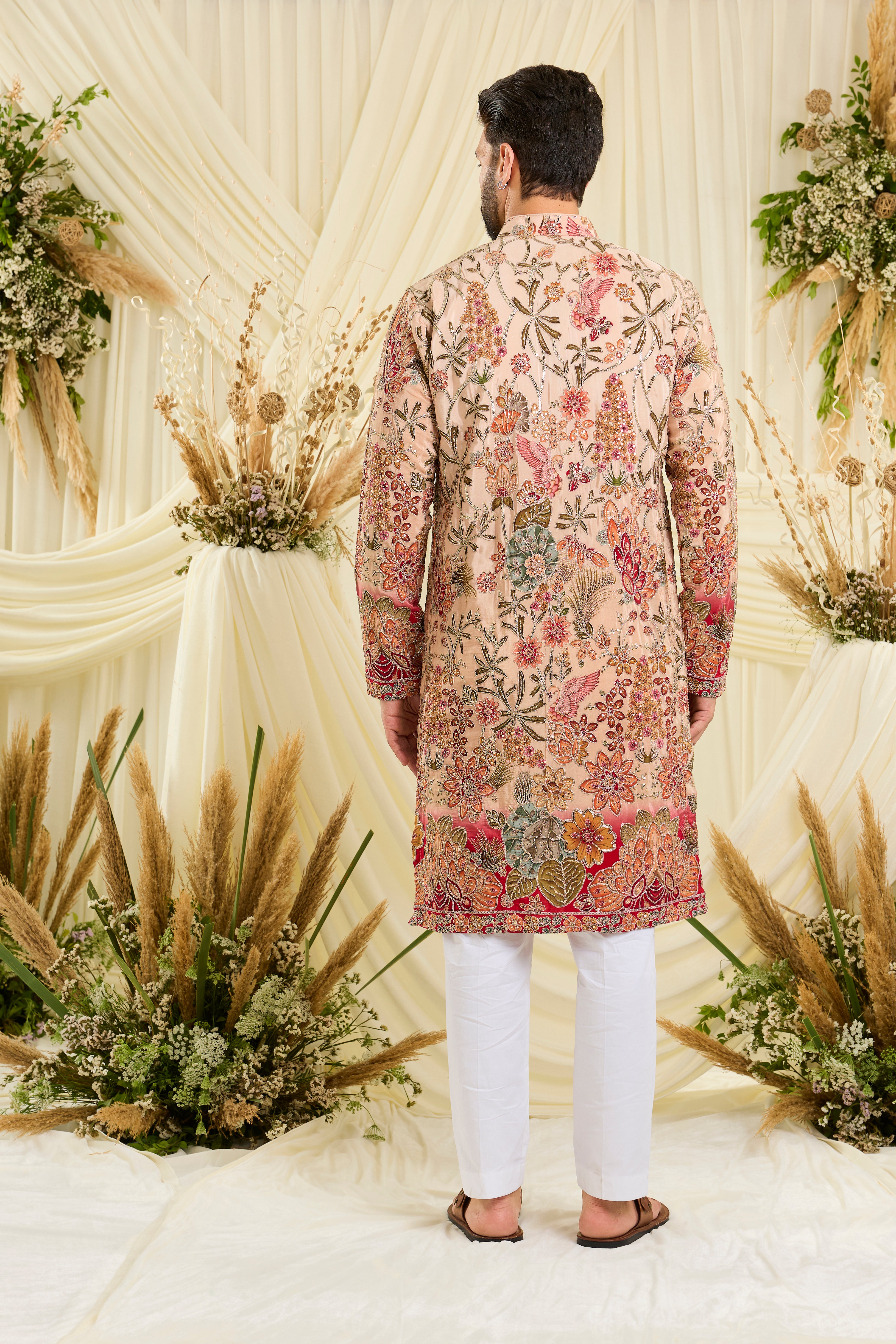 Pastel peach  kurta with intricate floral embroidery, rich zari detailing, and delicate sequins for a refined, luminous festive statement.