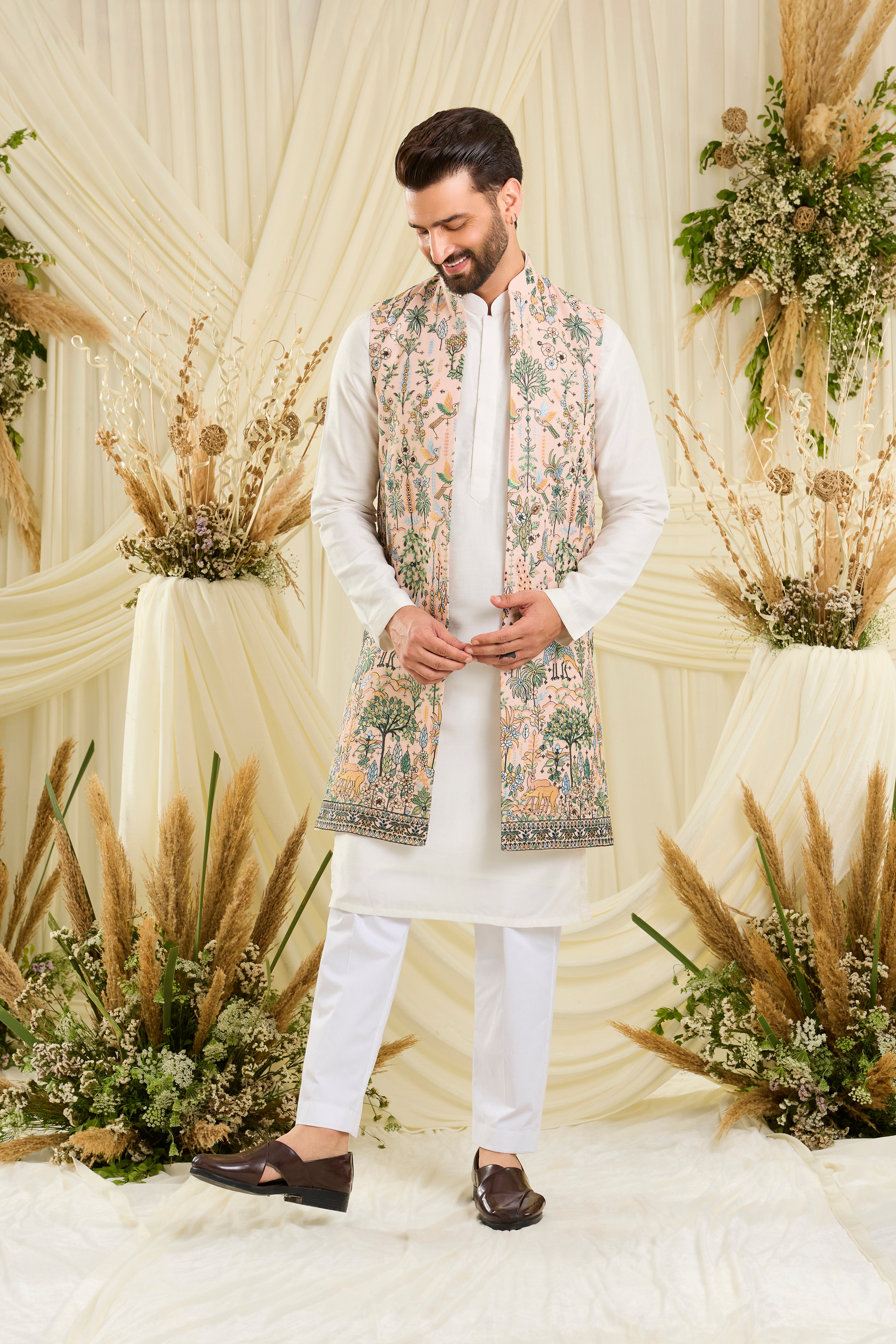 Light peach long open jacket with intricate flora-fauna embroidery, multicolour threadwork, and delicate sequins for a fresh, elevated festive look.