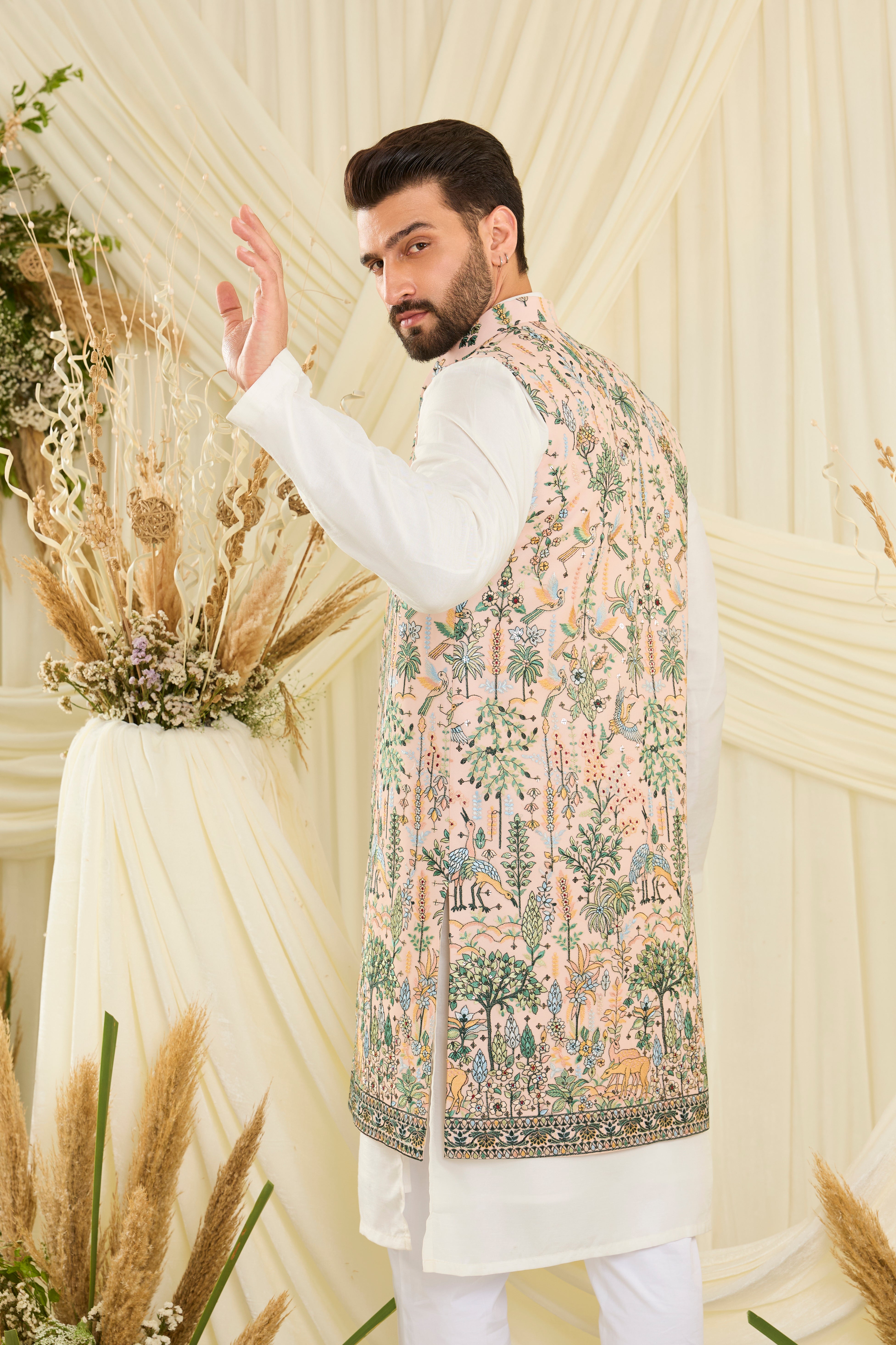 Light peach long open jacket with intricate flora-fauna embroidery, multicolour threadwork, and delicate sequins for a fresh, elevated festive look.