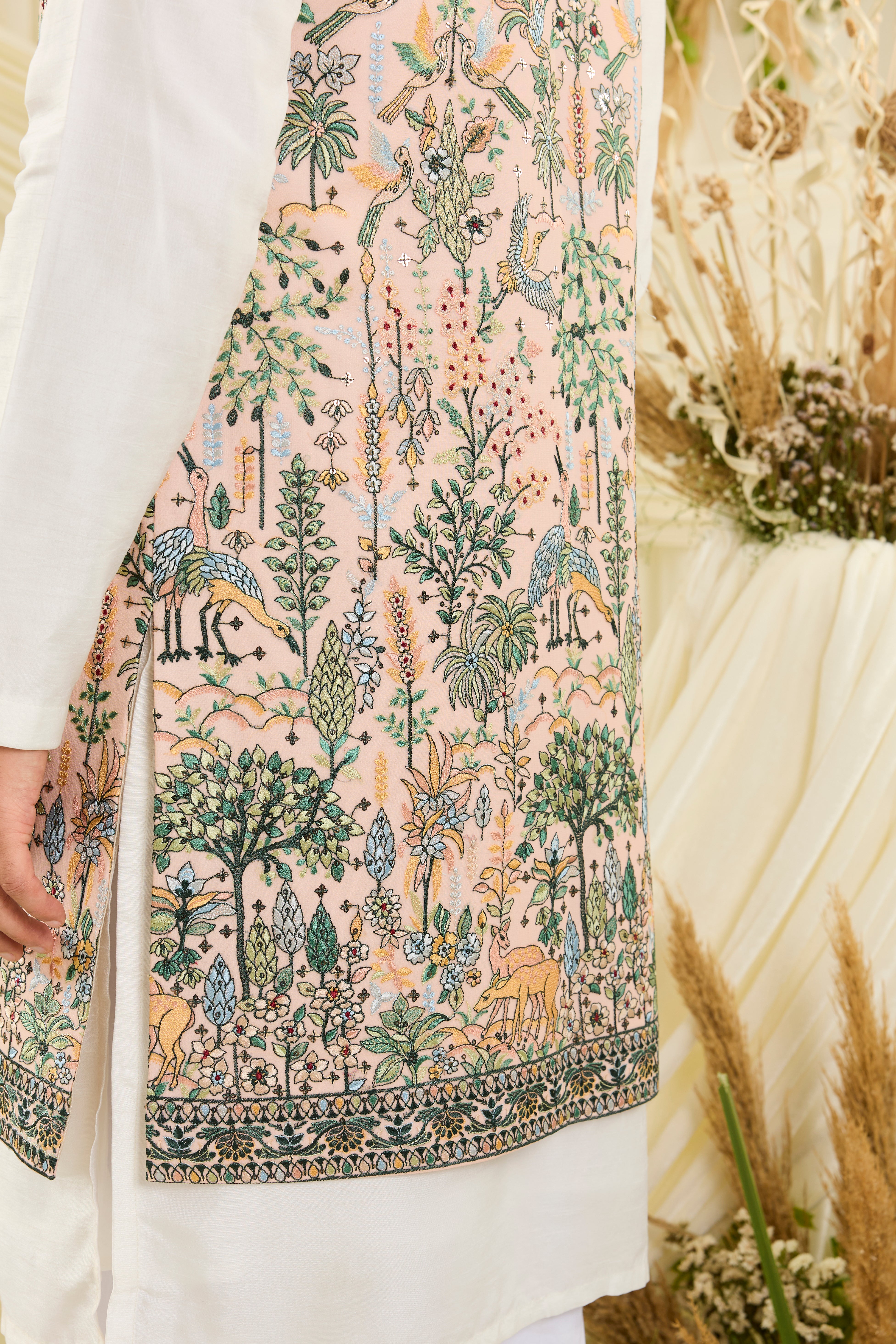 Light peach long open jacket with intricate flora-fauna embroidery, multicolour threadwork, and delicate sequins for a fresh, elevated festive look.