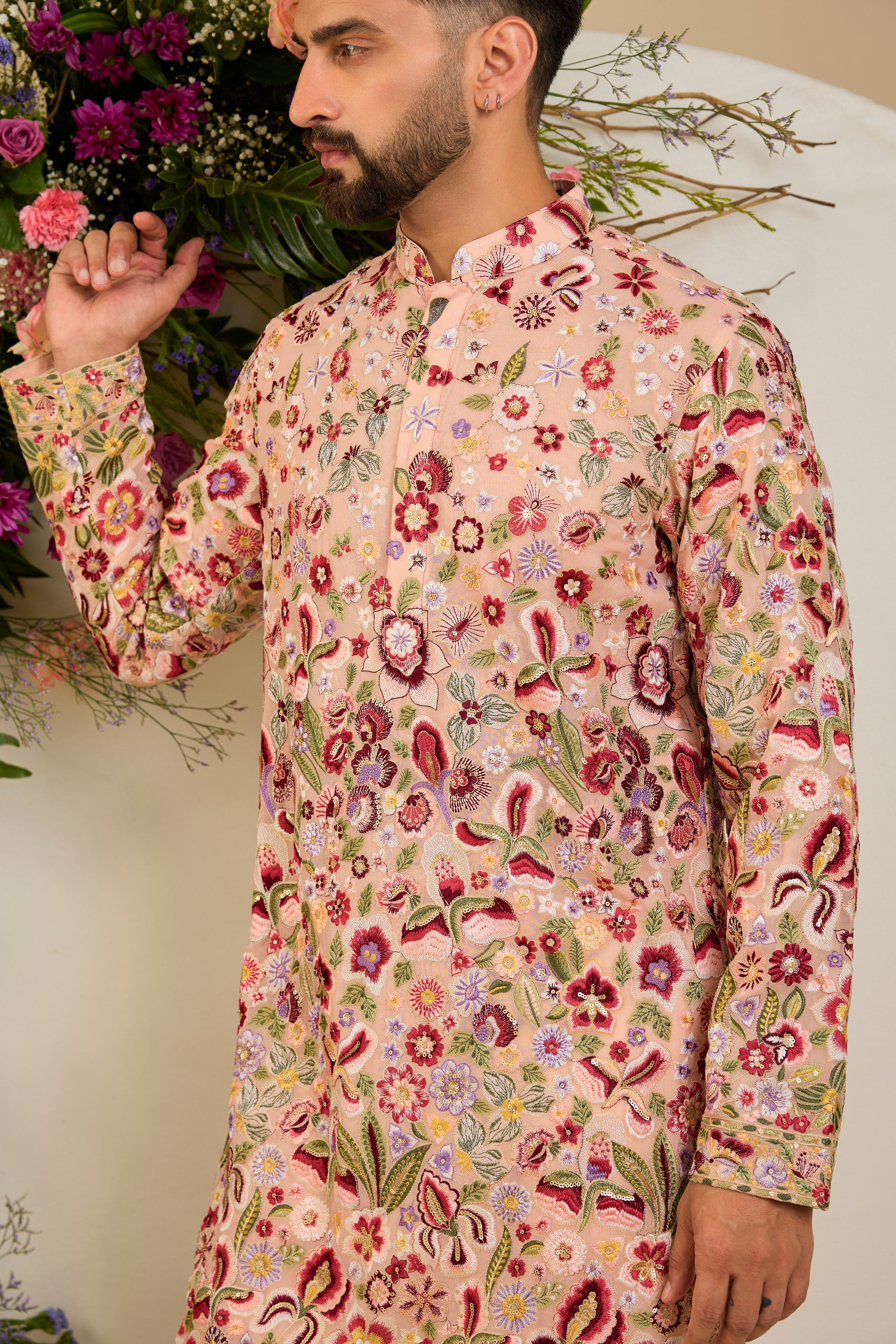 Blush peach pastel kurta with a vibrant floral backdrop, multi-coloured thread embroidery, and delicate sequin detailing for timeless elegance.