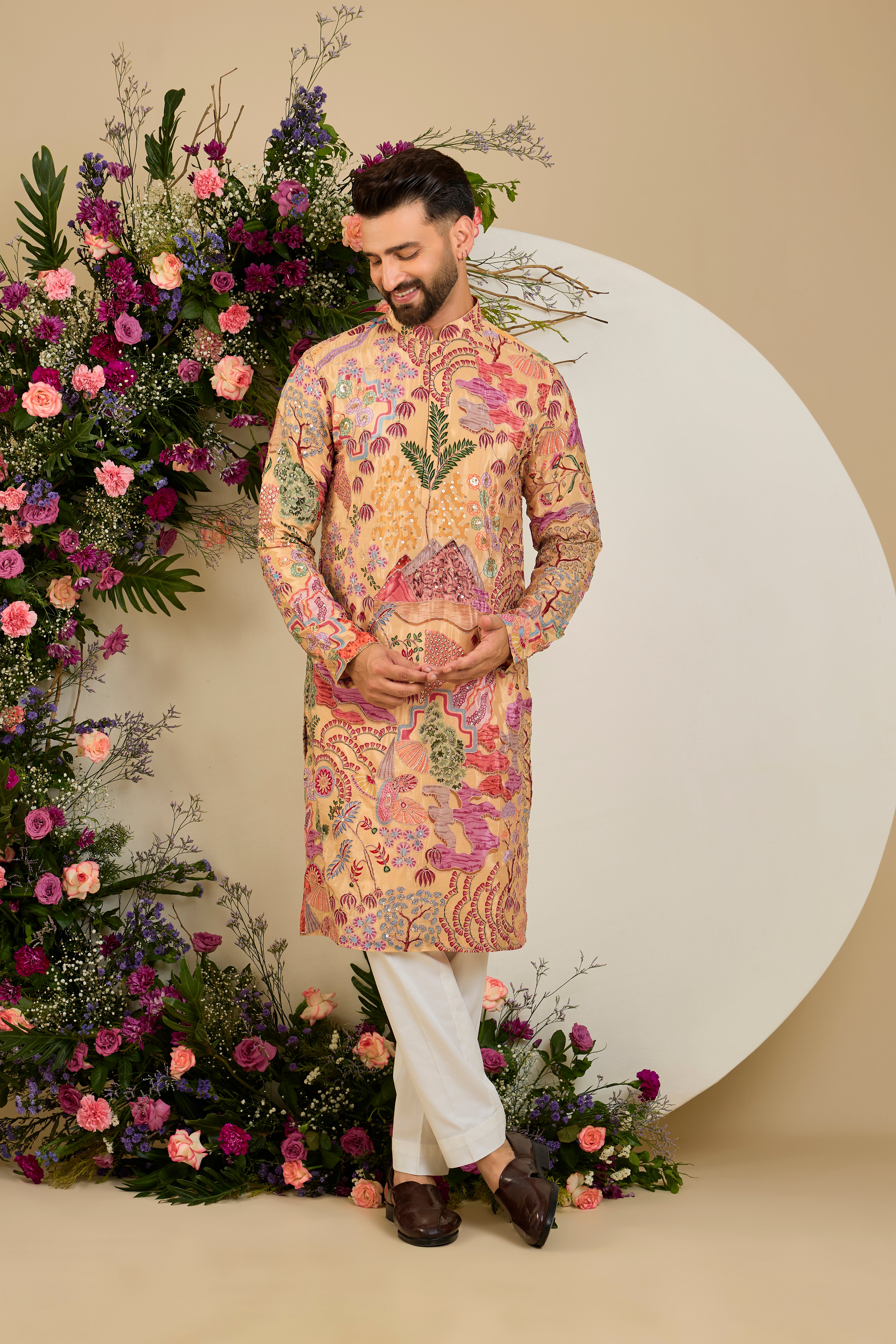 Tan peach crepe kurta with a botanical print, refined zari embroidery, and delicate sequin detailing for elevated occasion dressing.