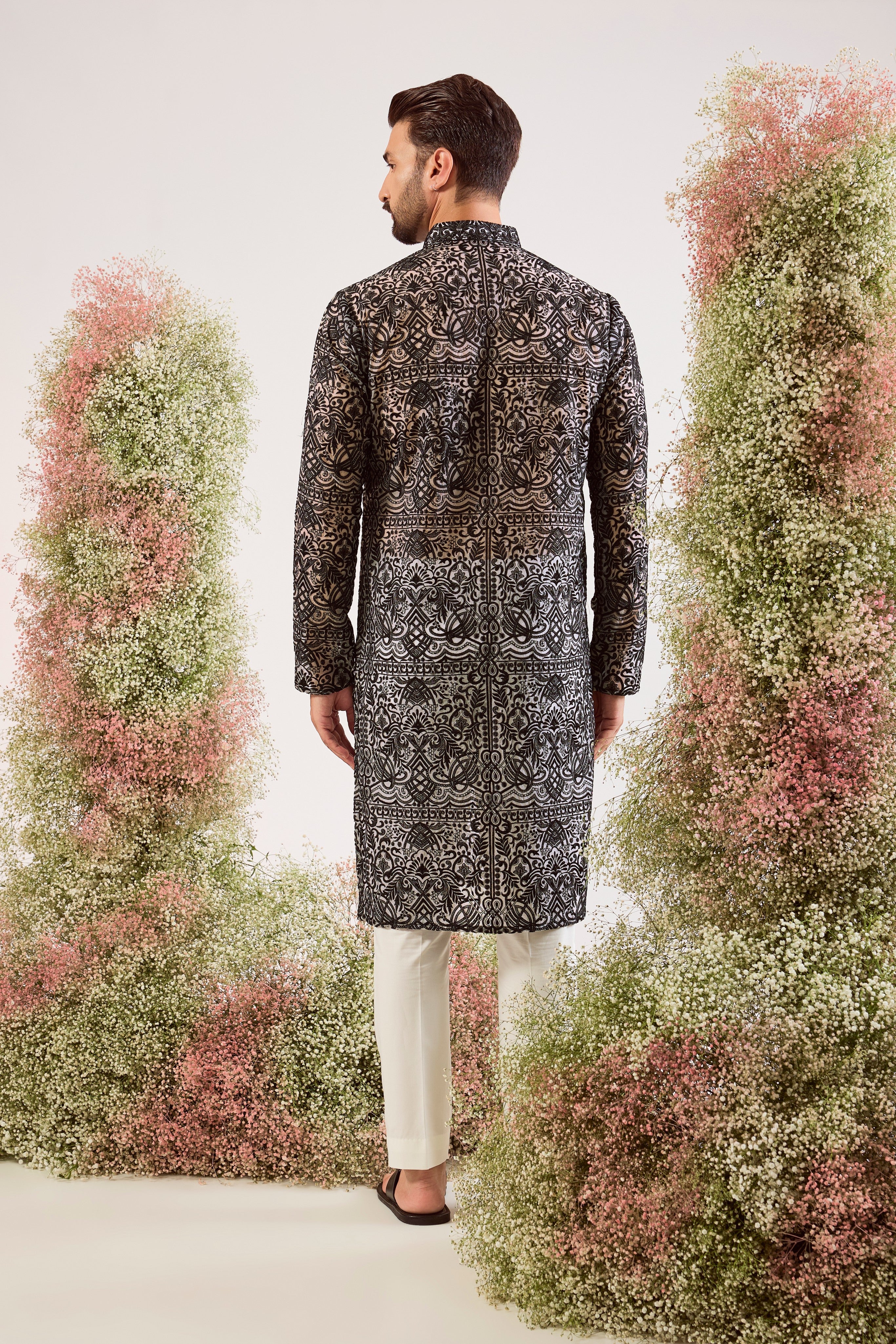 This striking black chikankari long see-through kurta is a masterpiece of modern elegance.