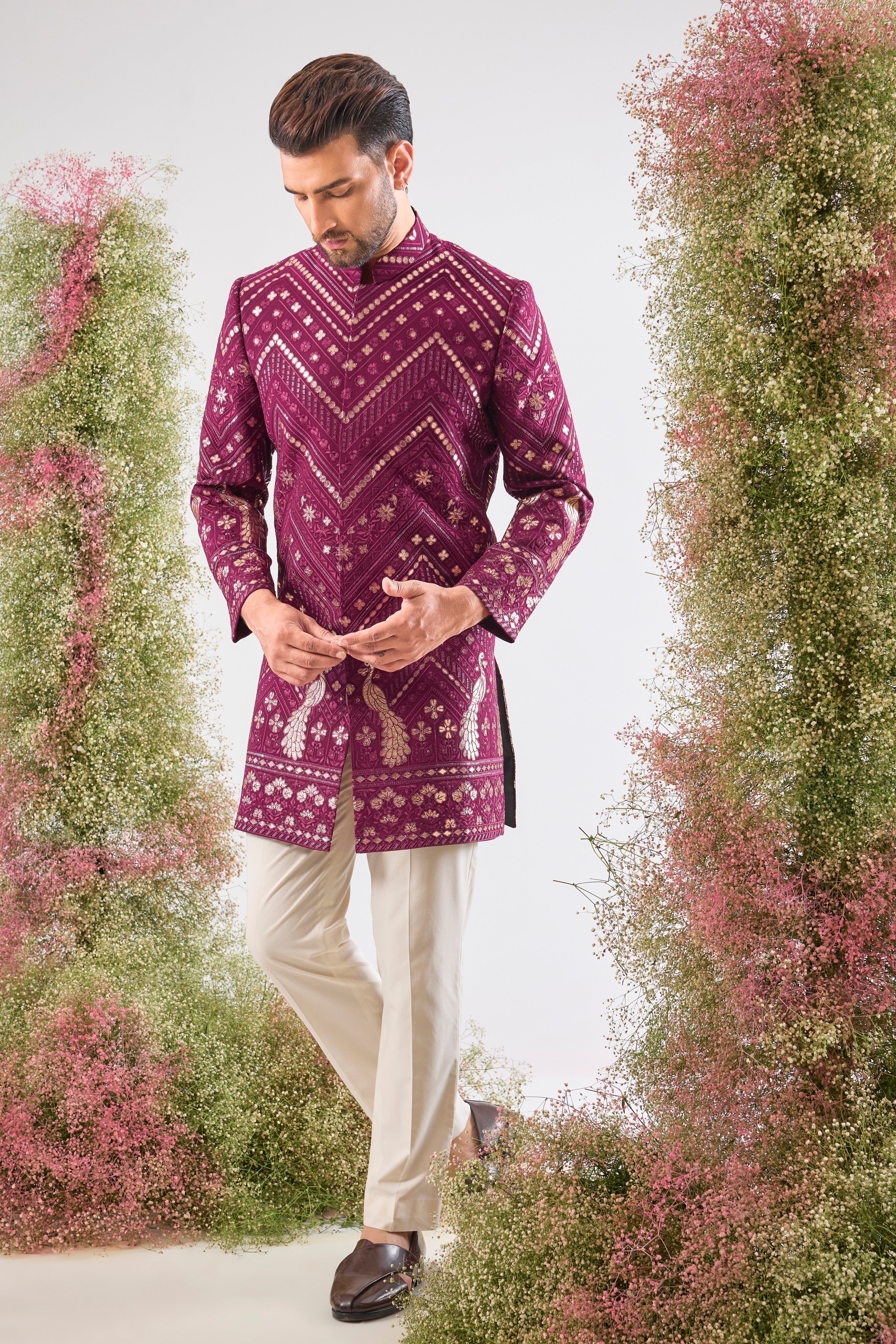 Introducing the statement piece you need: our Magenta Short Sherwani! 💖 This piece is a true work of art, featuring intricate Leather Patch Work highlighting majestic Peacock Motifs
