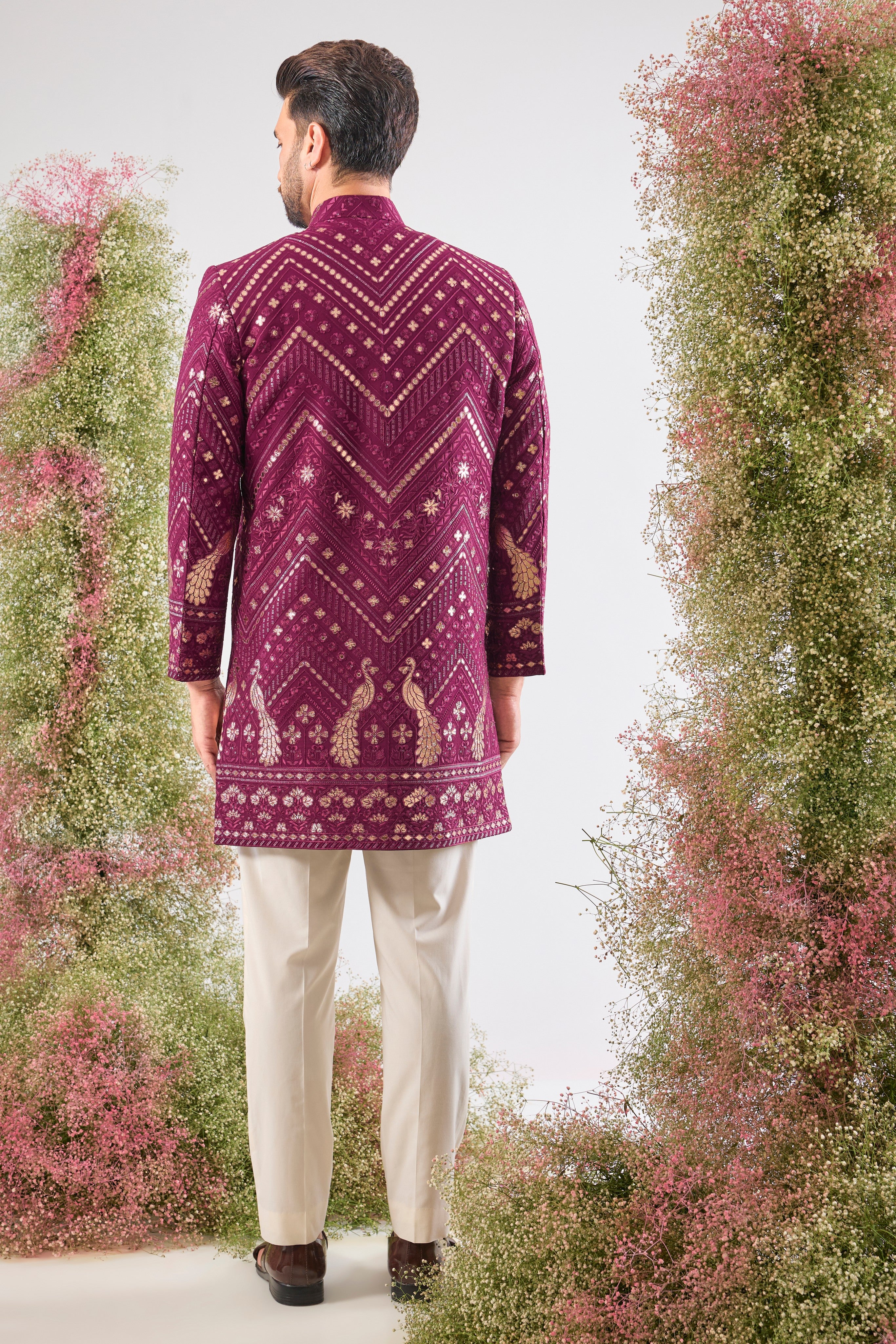 Introducing the statement piece you need: our Magenta Short Sherwani! 💖 This piece is a true work of art, featuring intricate Leather Patch Work highlighting majestic Peacock Motifs