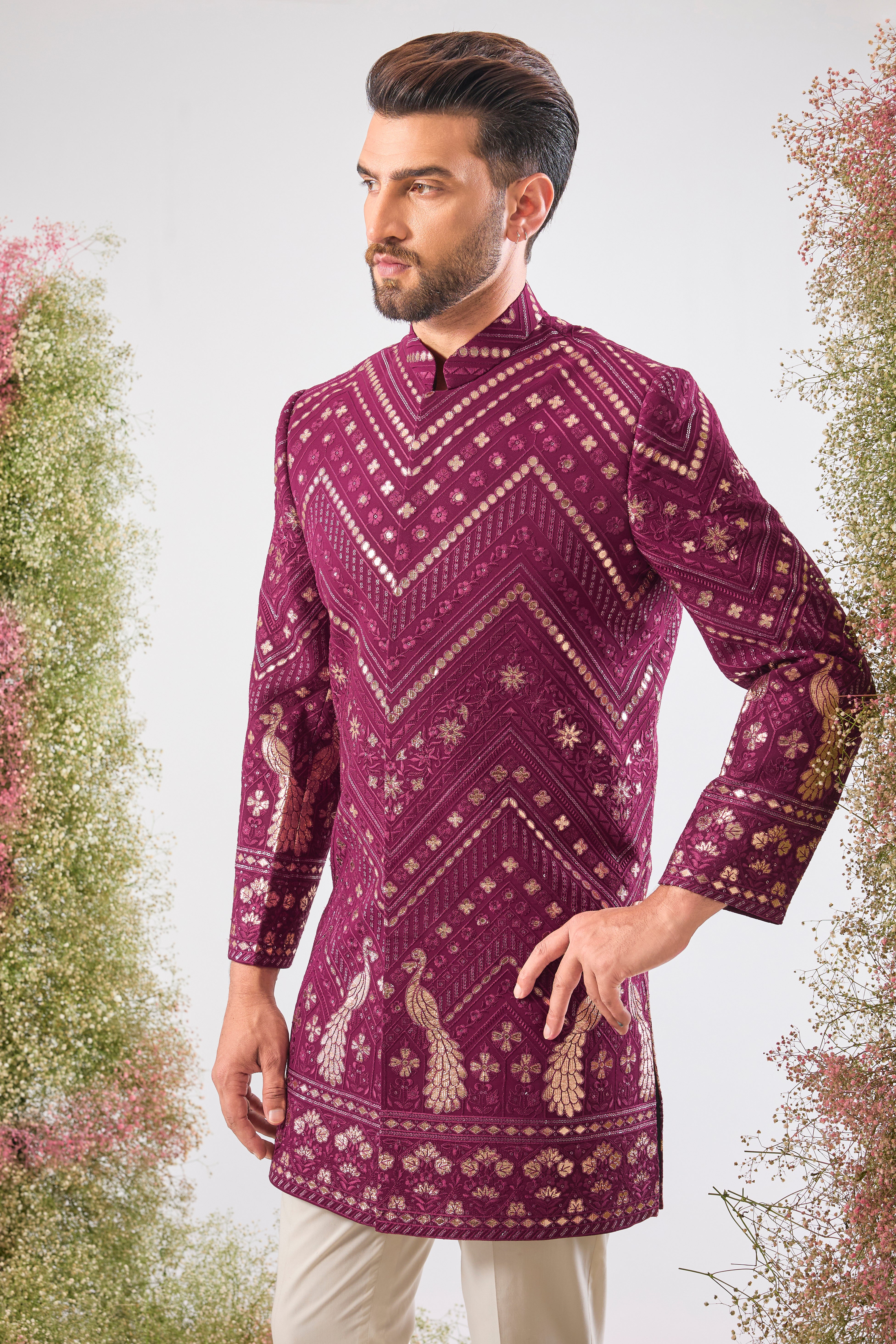 Introducing the statement piece you need: our Magenta Short Sherwani! 💖 This piece is a true work of art, featuring intricate Leather Patch Work highlighting majestic Peacock Motifs