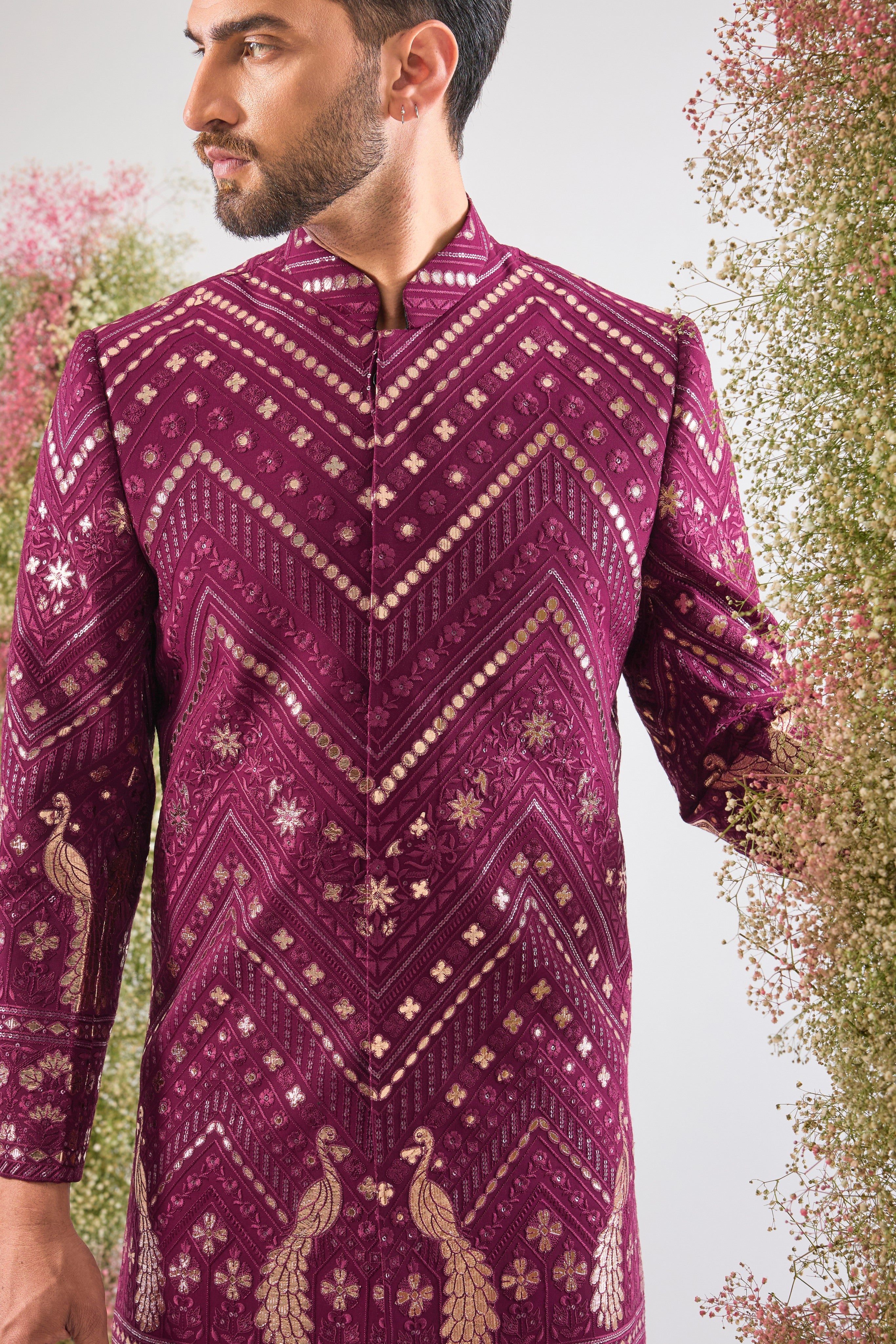 Introducing the statement piece you need: our Magenta Short Sherwani! 💖 This piece is a true work of art, featuring intricate Leather Patch Work highlighting majestic Peacock Motifs