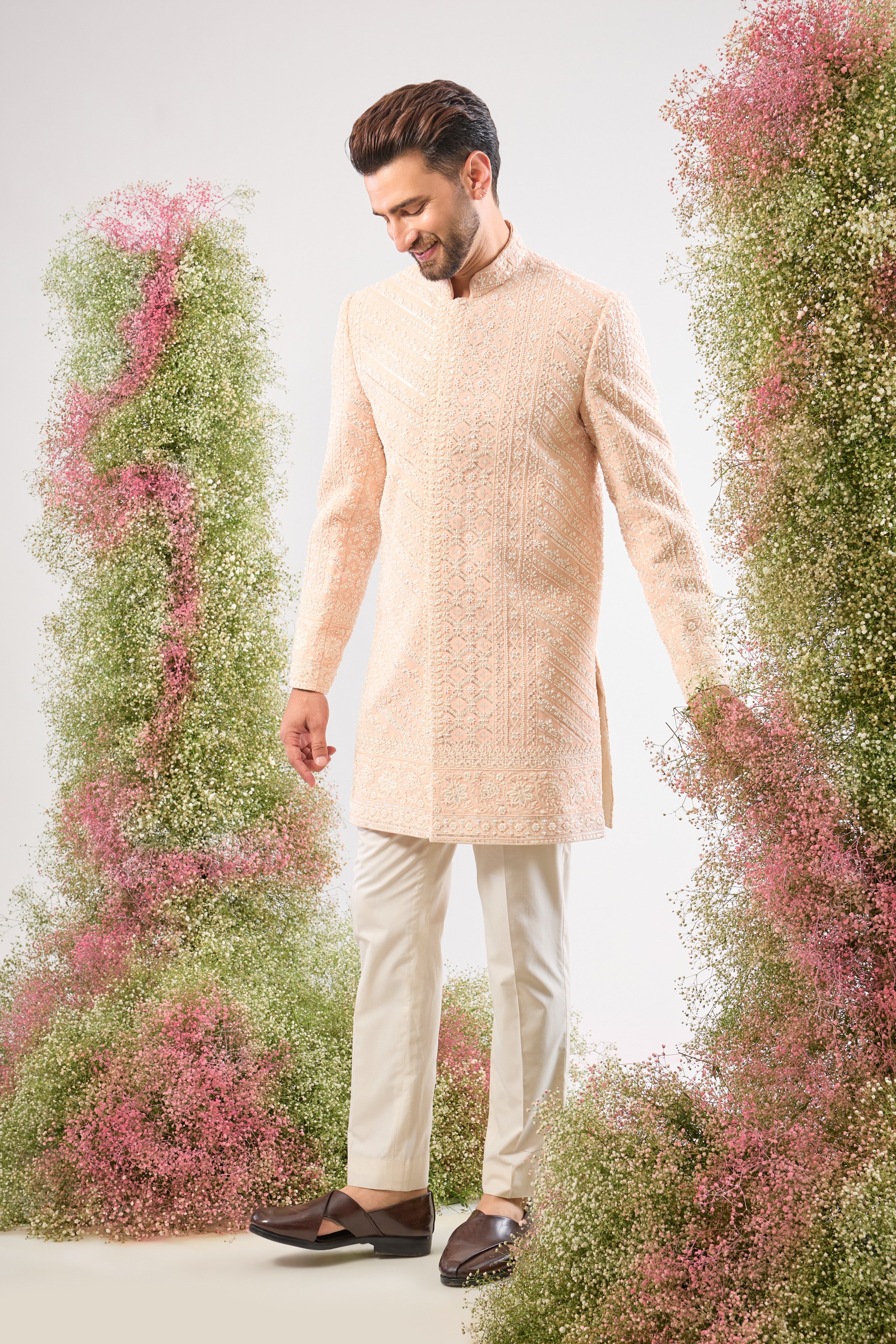 Introducing a truly One-of-a-Kind piece: our stunning Pink Short Sherwani. This is a Super Heavy Sherwani, adorned entirely with magnificent All Hand Work White Cut Dana and breathtakingly Detailed Sequin Work. ✨