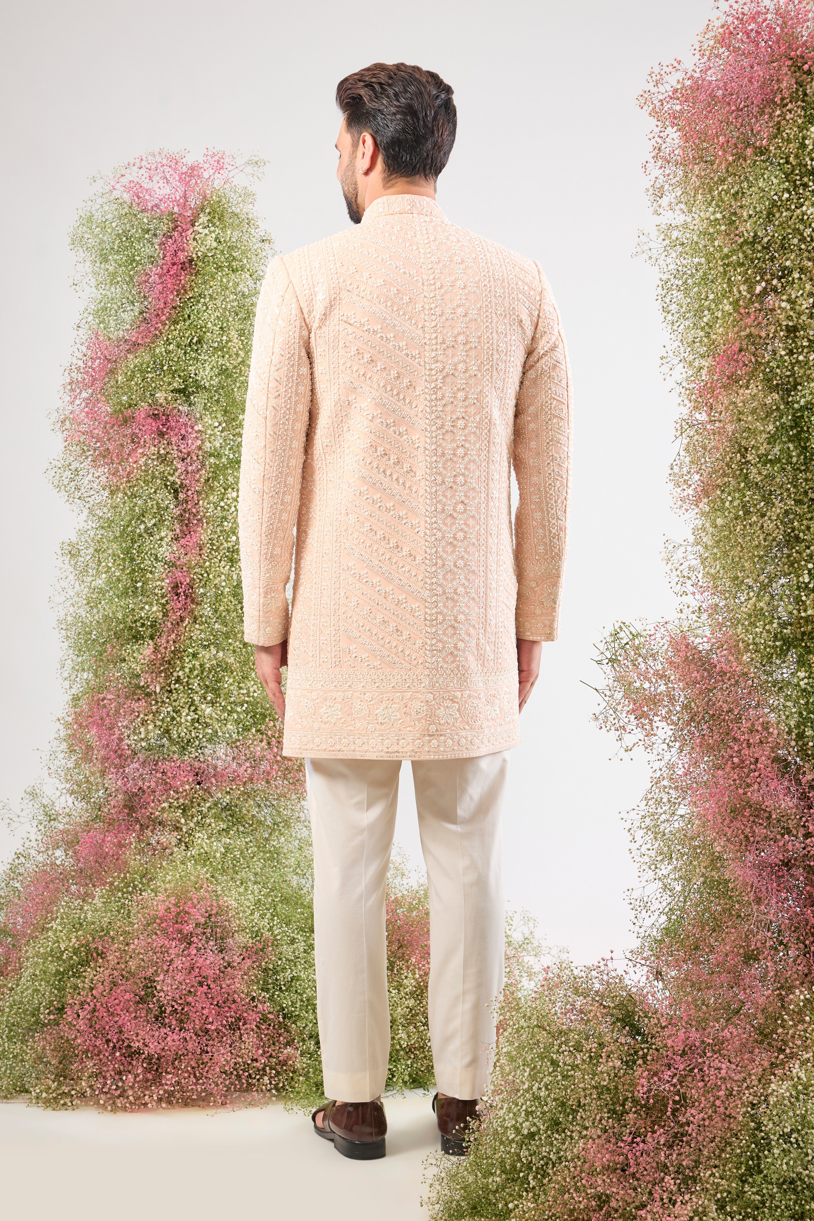 Introducing a truly One-of-a-Kind piece: our stunning Pink Short Sherwani. This is a Super Heavy Sherwani, adorned entirely with magnificent All Hand Work White Cut Dana and breathtakingly Detailed Sequin Work. ✨