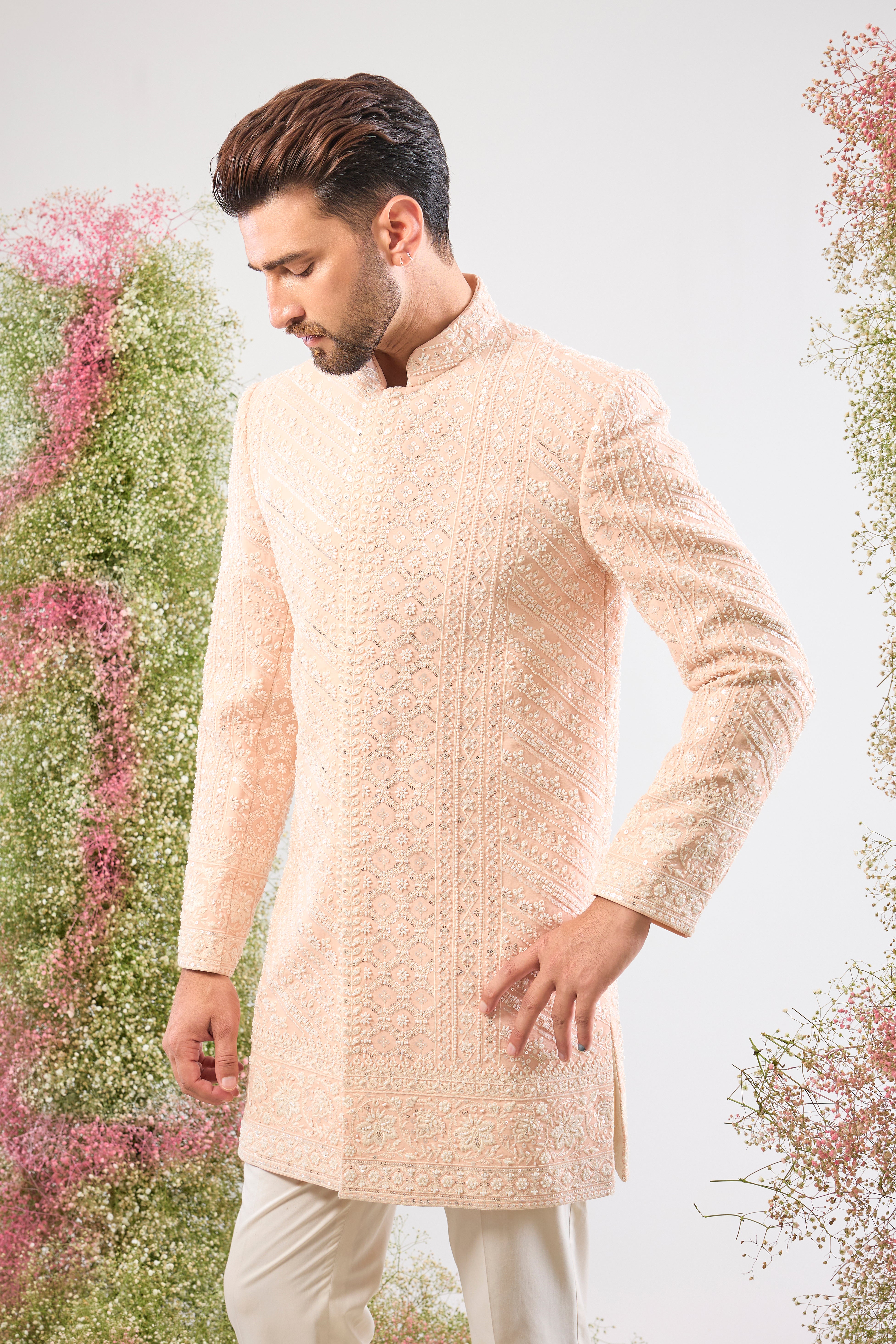 Introducing a truly One-of-a-Kind piece: our stunning Pink Short Sherwani. This is a Super Heavy Sherwani, adorned entirely with magnificent All Hand Work White Cut Dana and breathtakingly Detailed Sequin Work. ✨