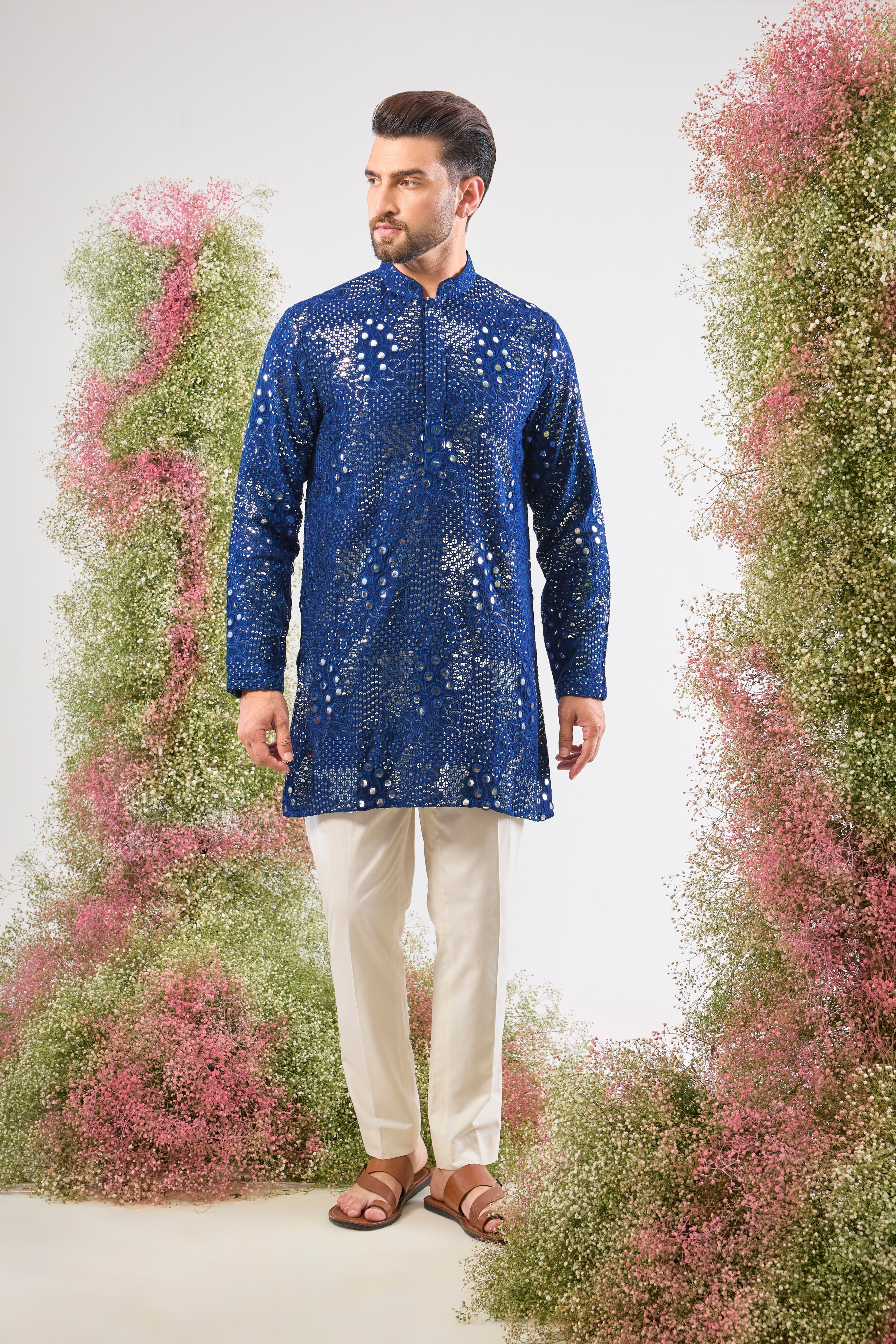 A harmonious blend of craft and colour. This bright Blue Mirror Work Kurta showcases Tone-to-Tone Thread Work and stunning Intricate Floral Patterns, all illuminated by sparkling sequin detailing.