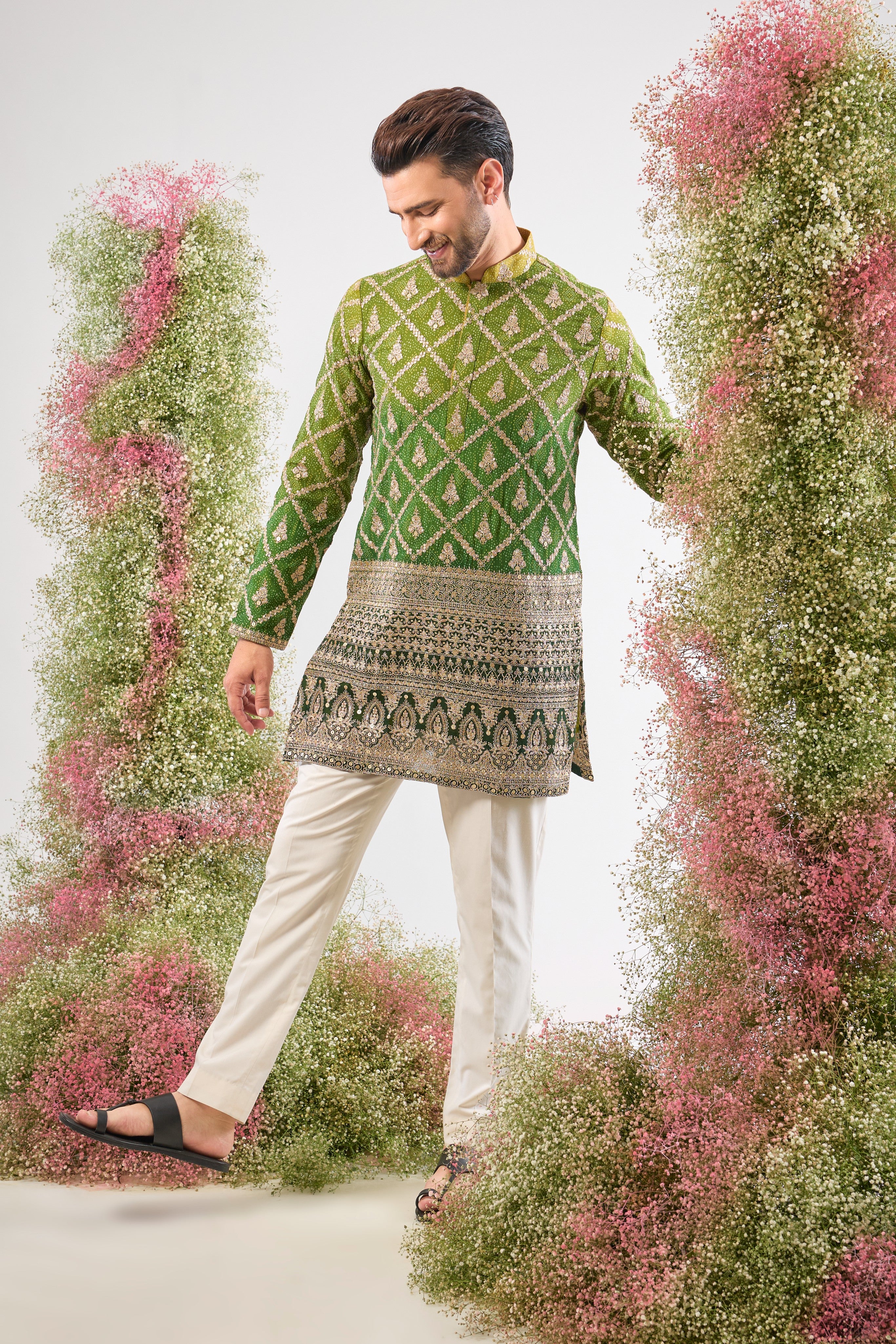 his Green Bandhani Print Short Kurta features an exceptionally rich Heavy Zari Work Border and sparkling sequin detailing. The contrast between the lively print and the dense embroidery is simply magnificent.
