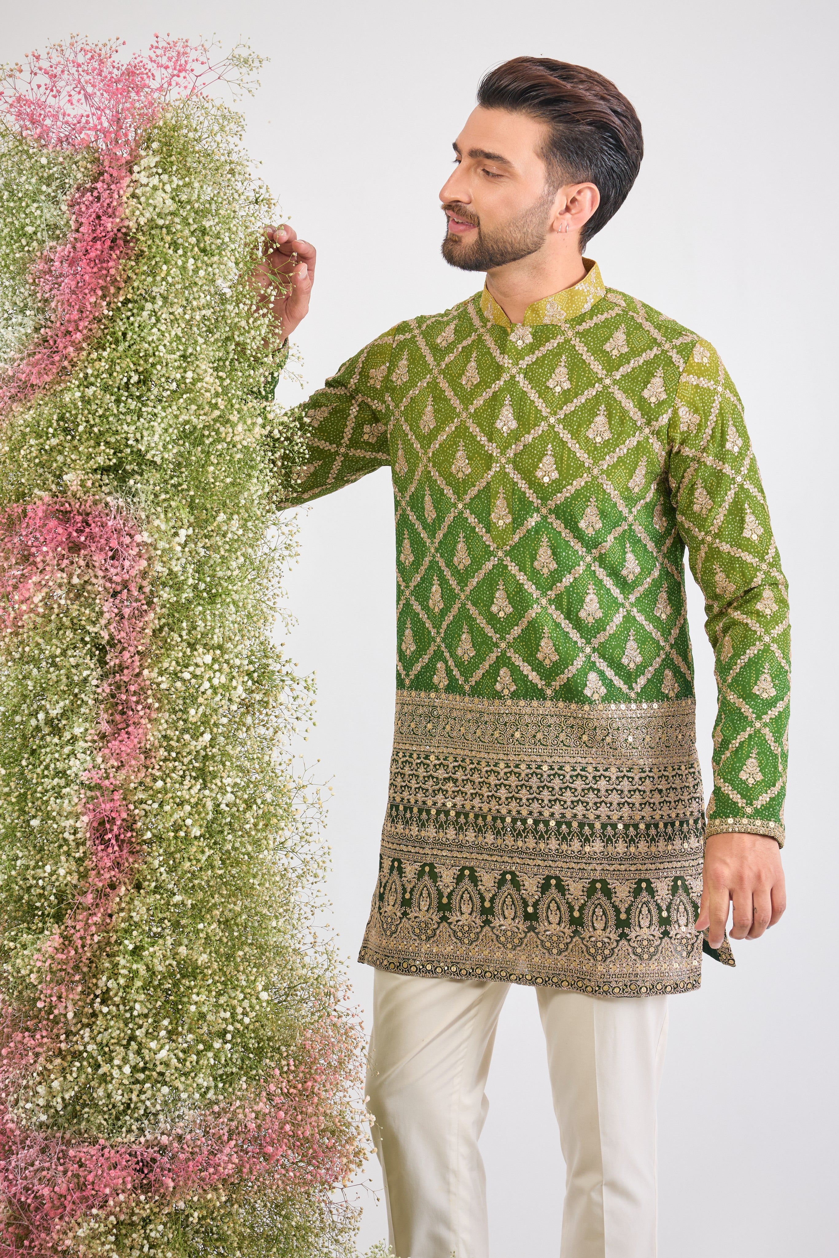 his Green Bandhani Print Short Kurta features an exceptionally rich Heavy Zari Work Border and sparkling sequin detailing. The contrast between the lively print and the dense embroidery is simply magnificent.