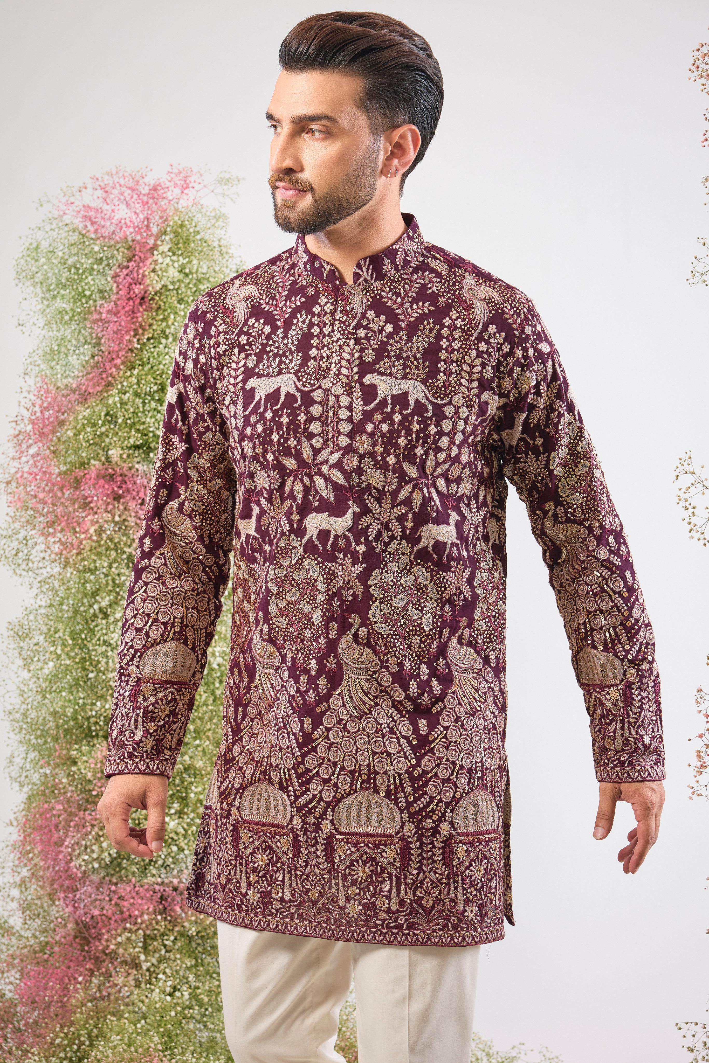 This Wine Short Kurta showcases stunning artistry, where Detailed Royal Darbars meet lush Flora and Fauna Figures. The entire design is beautifully textured and illuminated by rich Zari and Sequins.