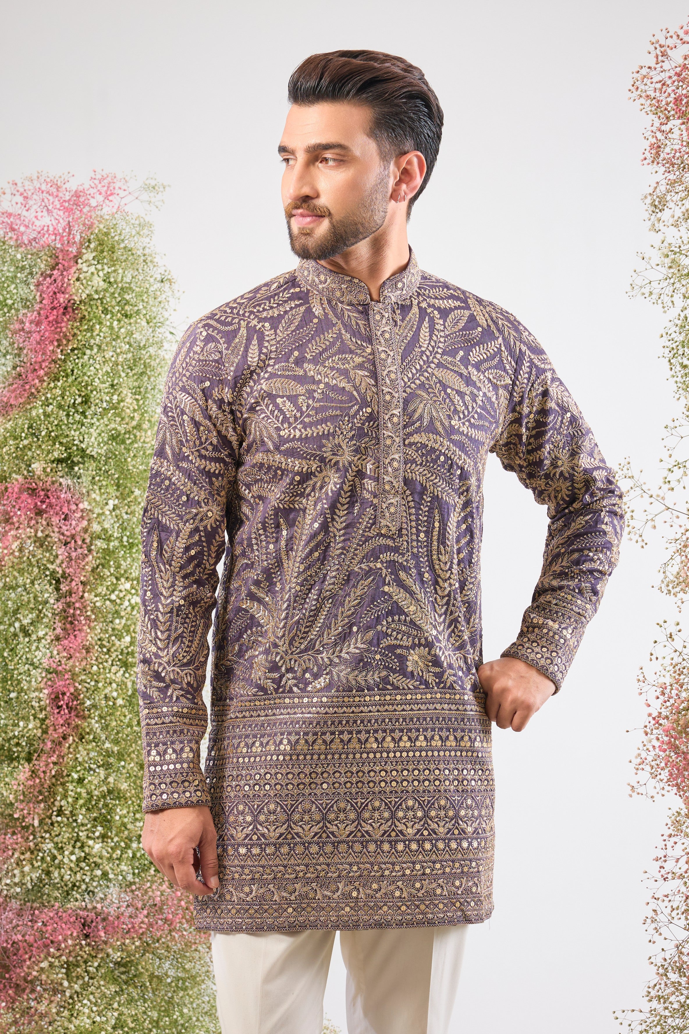 his Purple Mauve Short Zari Kurta is adorned with exquisite Detailed Floral Embroidery and shimmering sequins, creating incredible texture. The classic heavy ghera adds a majestic flow to the short silhouette.