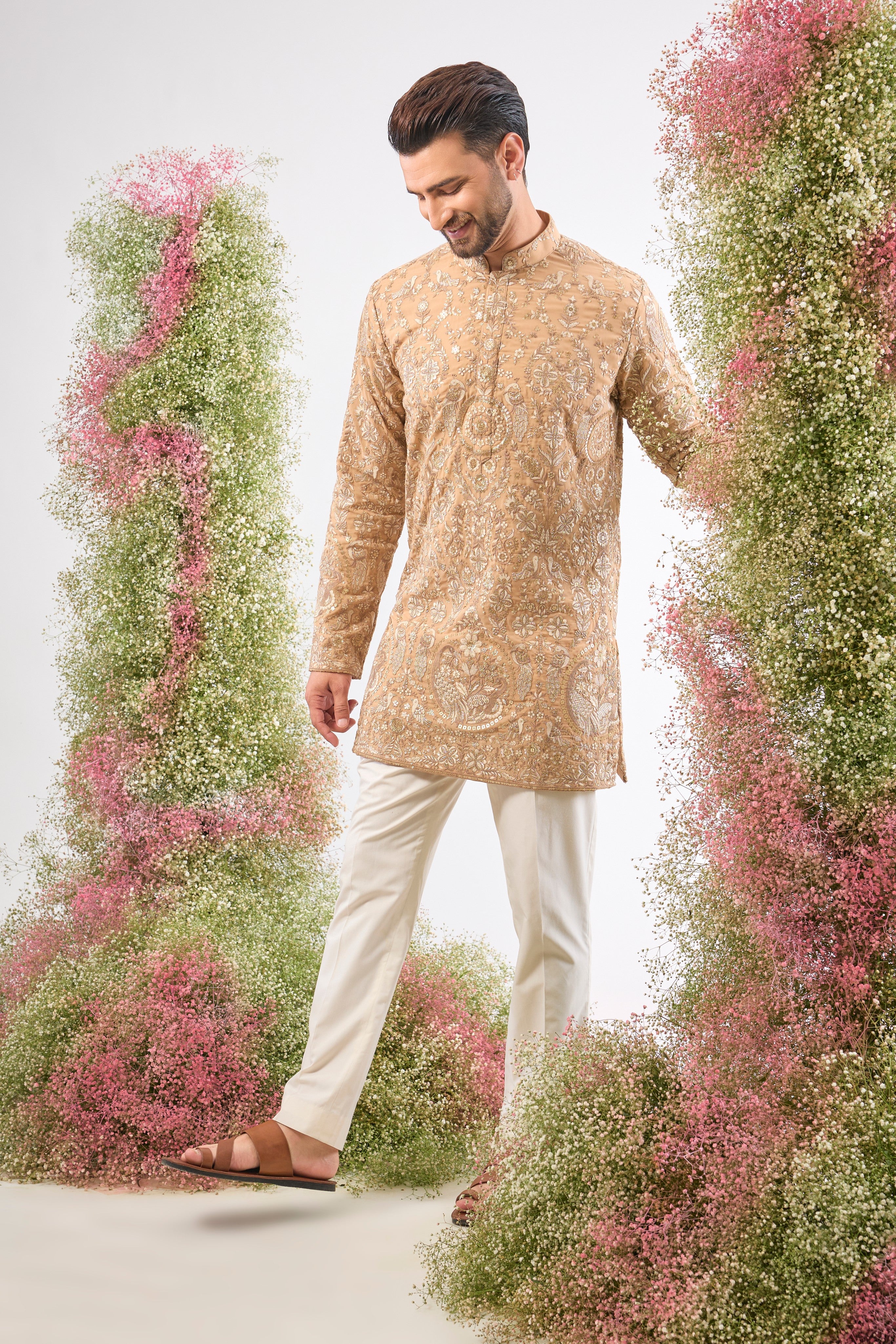 This Nude Short Kurta showcases magnificent Detailed Flora and Fauna Figures, creating depth and texture on the fabric. The combination of fine Zari and Sequin Work offers a delicate yet compelling shimmer.