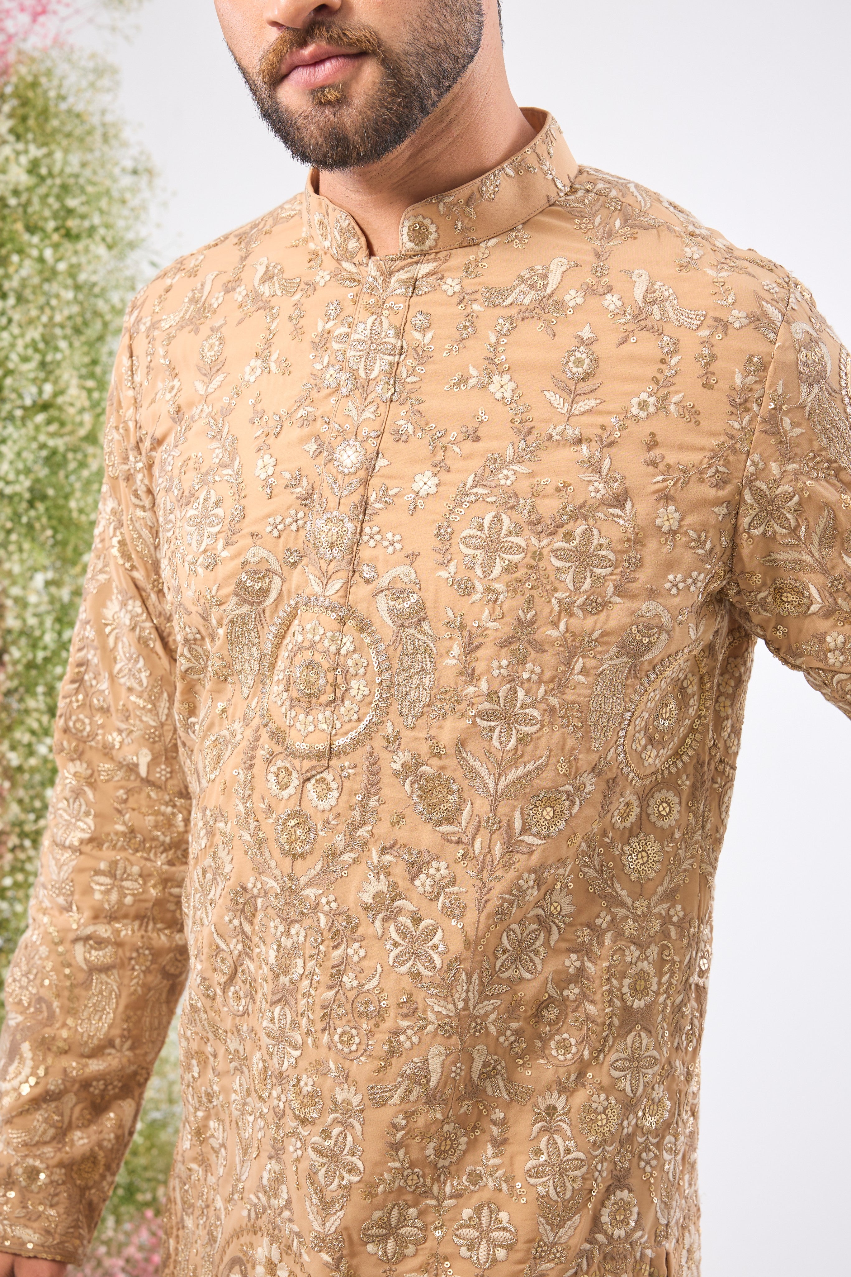 This Nude Short Kurta showcases magnificent Detailed Flora and Fauna Figures, creating depth and texture on the fabric. The combination of fine Zari and Sequin Work offers a delicate yet compelling shimmer.
