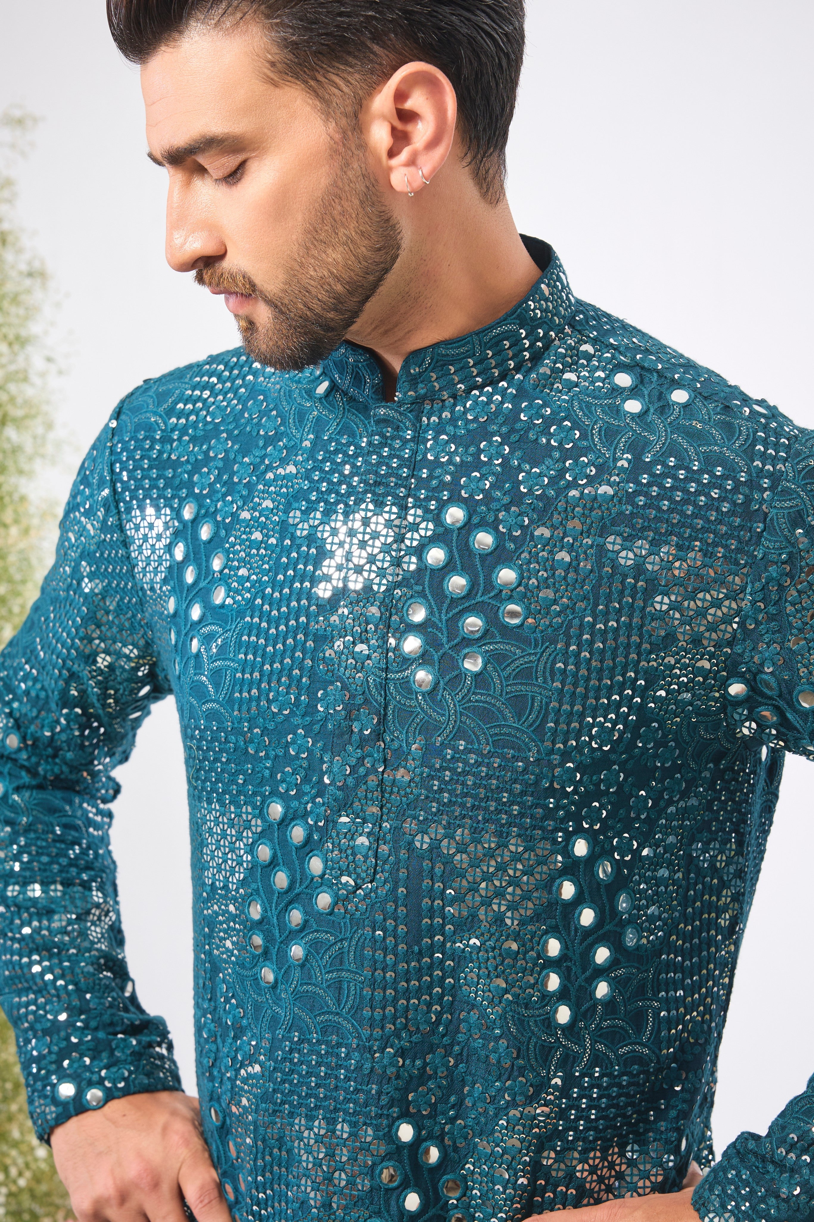 This Teal Mirror Work Kurta showcases exquisite Intricate Floral Patterns, beautifully highlighted by the reflective Sequin Work. The combination creates depth, vibrancy, and a continuous, captivating shimmer.