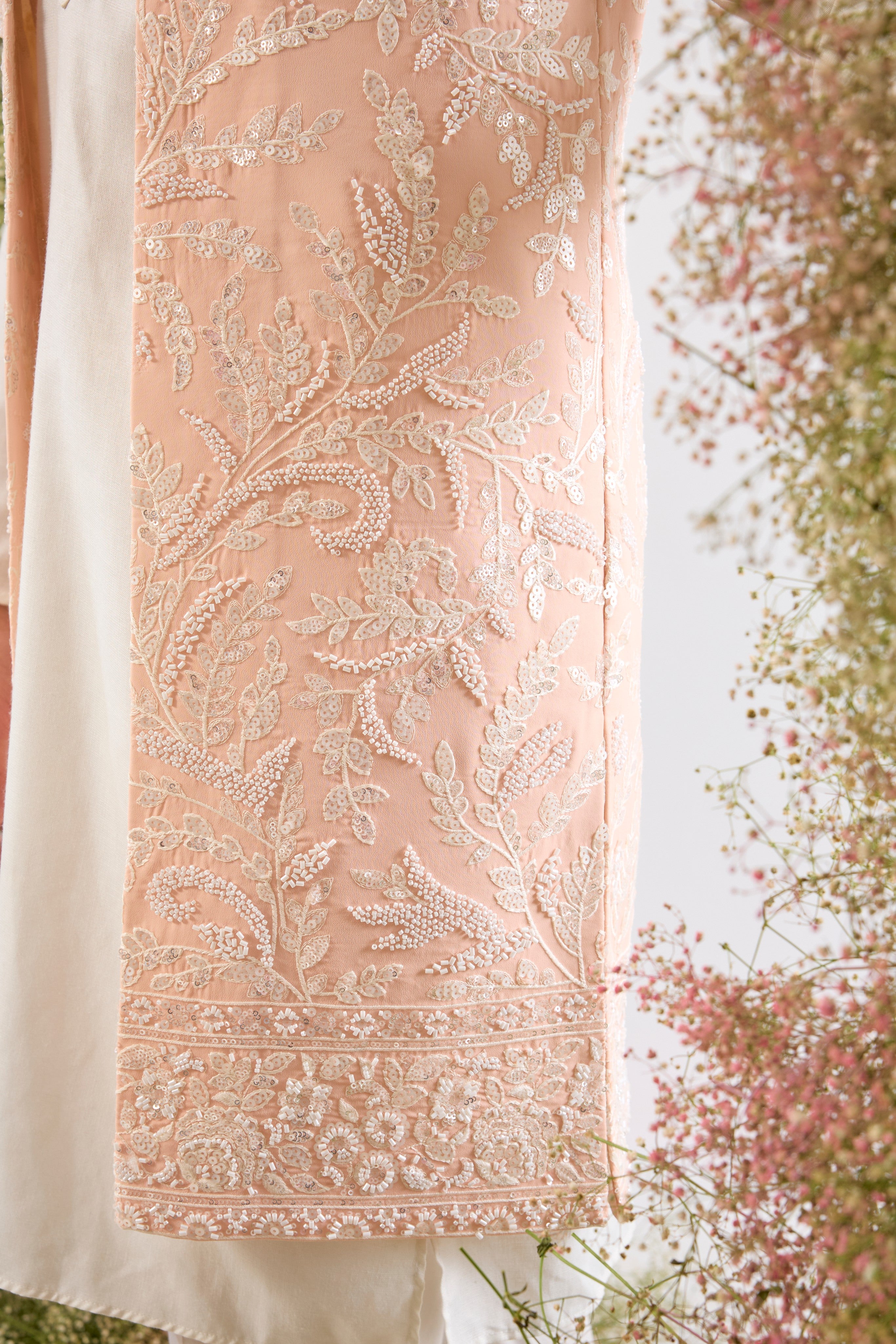 Handcrafted perfection. Our Long Open Jacket features detailed Hind Hand Work, luminous White Cut Dana, sequins, and a delicate Floral Pattern. Pure elegance.