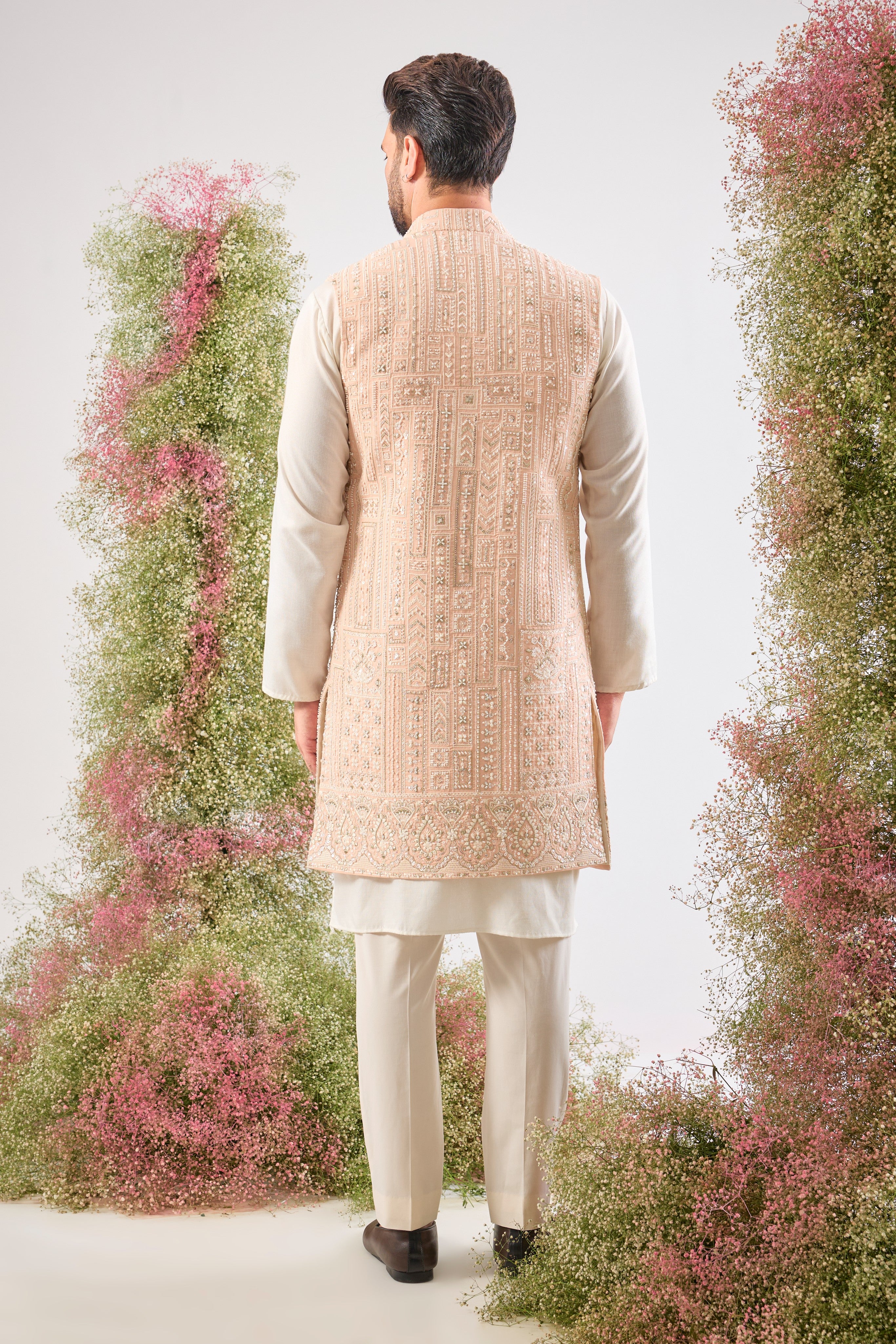 Our Long Open Jacket features exquisite Hind Hand Work, meticulously crafted with shimmering White Cut Dana and Sequin detailing arranged in a sharp Geometrical Pattern. This jacket is the perfect blend of artisanal skill and contemporary design.