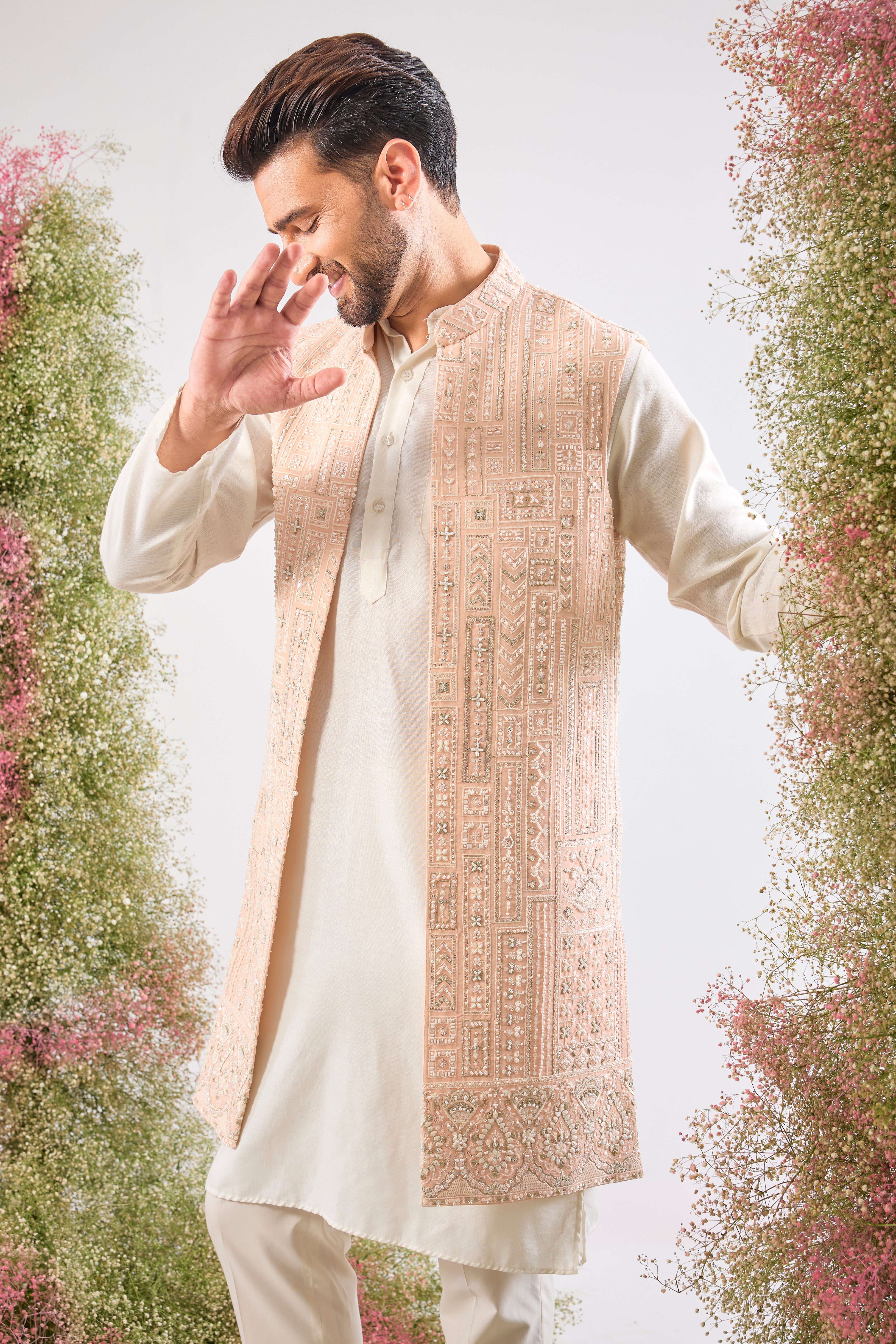 Our Long Open Jacket features exquisite Hind Hand Work, meticulously crafted with shimmering White Cut Dana and Sequin detailing arranged in a sharp Geometrical Pattern. This jacket is the perfect blend of artisanal skill and contemporary design.