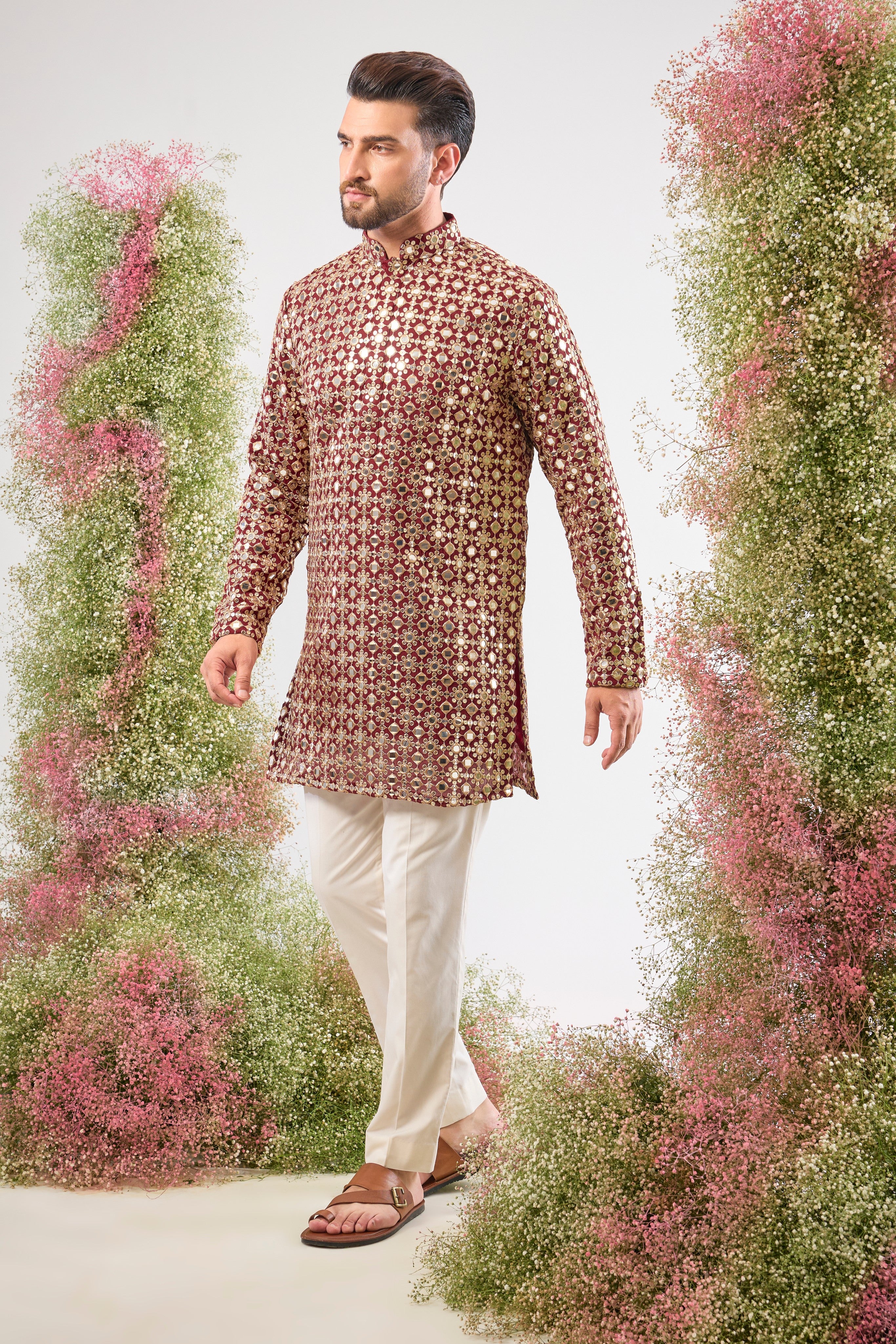 This Maroon Mirror Work Short Kurta showcases the dramatic texture of Heavy Zari Work, seamlessly blended with the brilliant shimmer of Detailed Sequins. The result is a garment that offers unmatched depth and sparkle, capturing light beautifully.