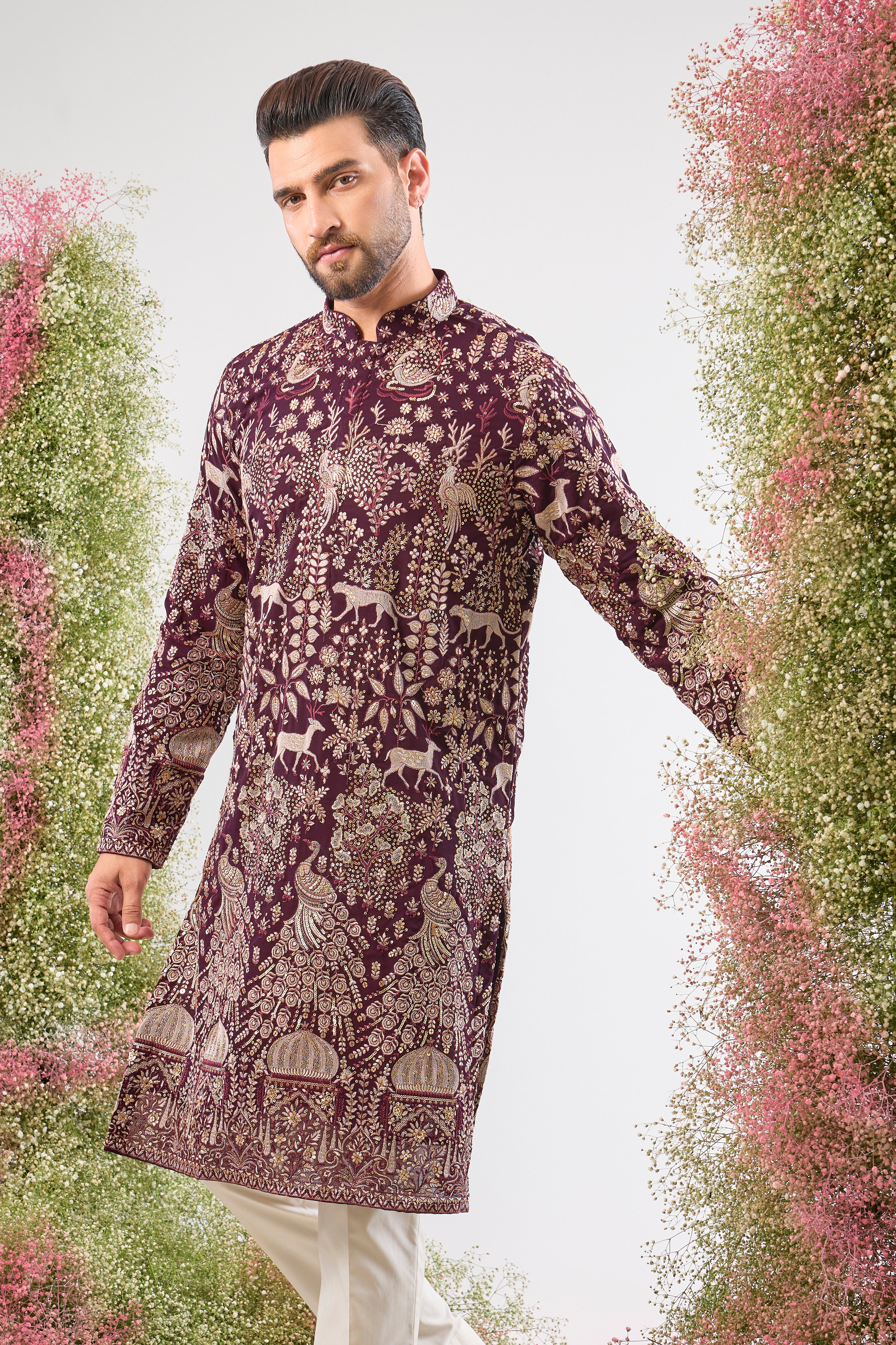 his Wine Long Kurta is super charming and very formal, showcasing intricate Royal Darbars alongside elegant Flora and Fauna motifs, all brought to life by dazzling Zari and Sequin work