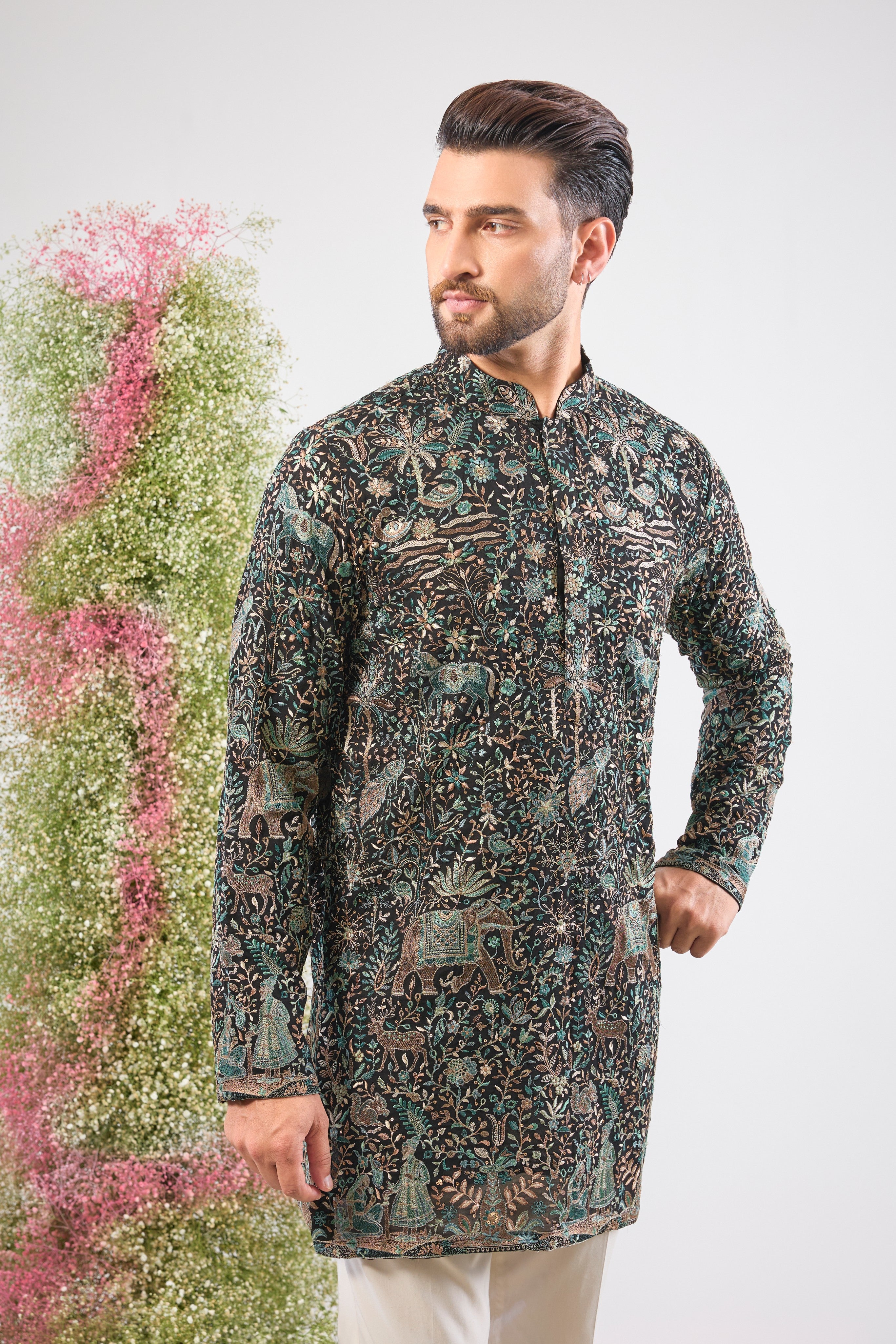 This Black Short Kurta is adorned with rich Kashmiri Embroidery, with every motif showcasing Detailed Flora and Fauna Embroidery. The sequin work provides a beautiful, reflective texture, ensuring a sophisticated and artistic presence at any event.