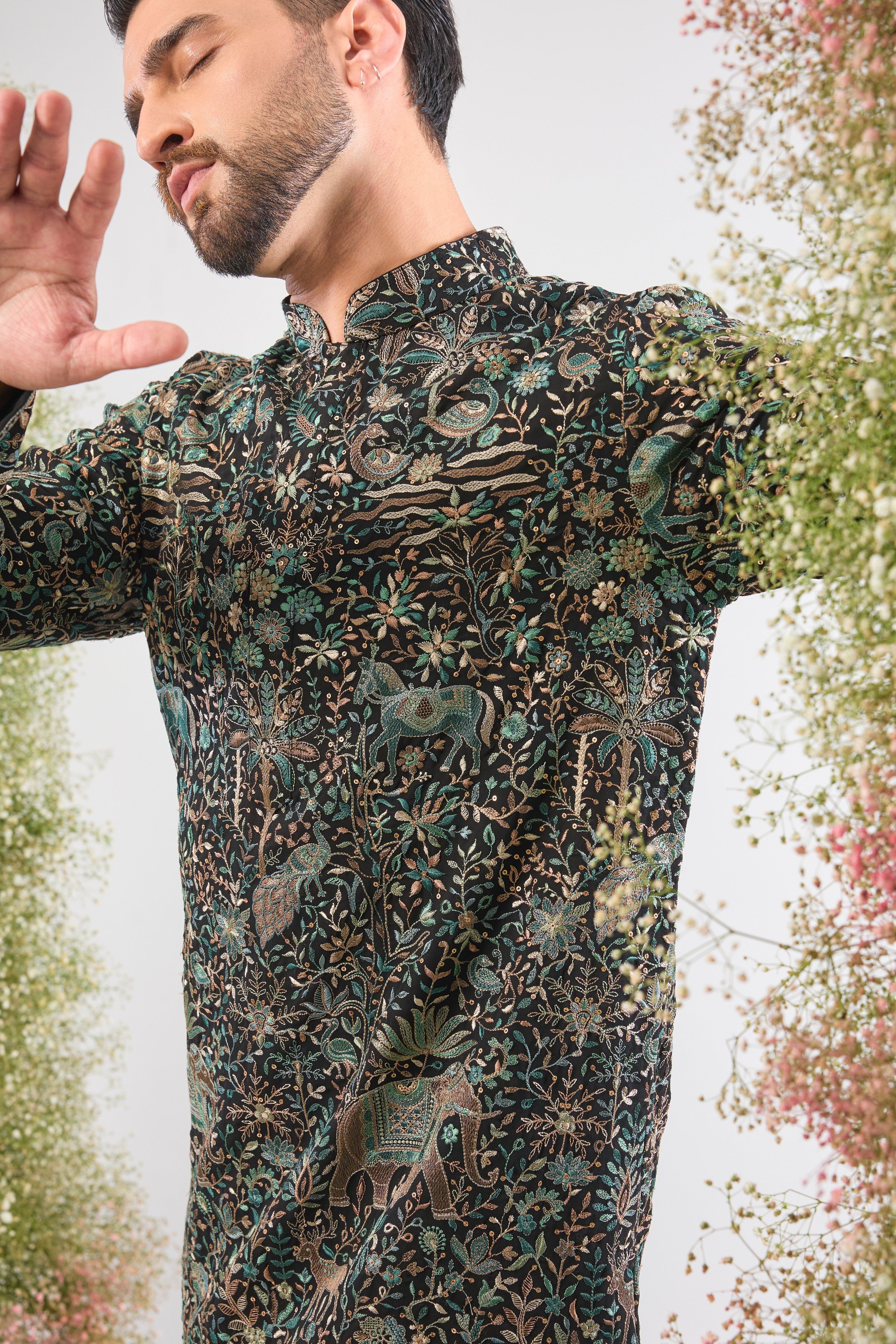 This Black Short Kurta is adorned with rich Kashmiri Embroidery, with every motif showcasing Detailed Flora and Fauna Embroidery. The sequin work provides a beautiful, reflective texture, ensuring a sophisticated and artistic presence at any event.