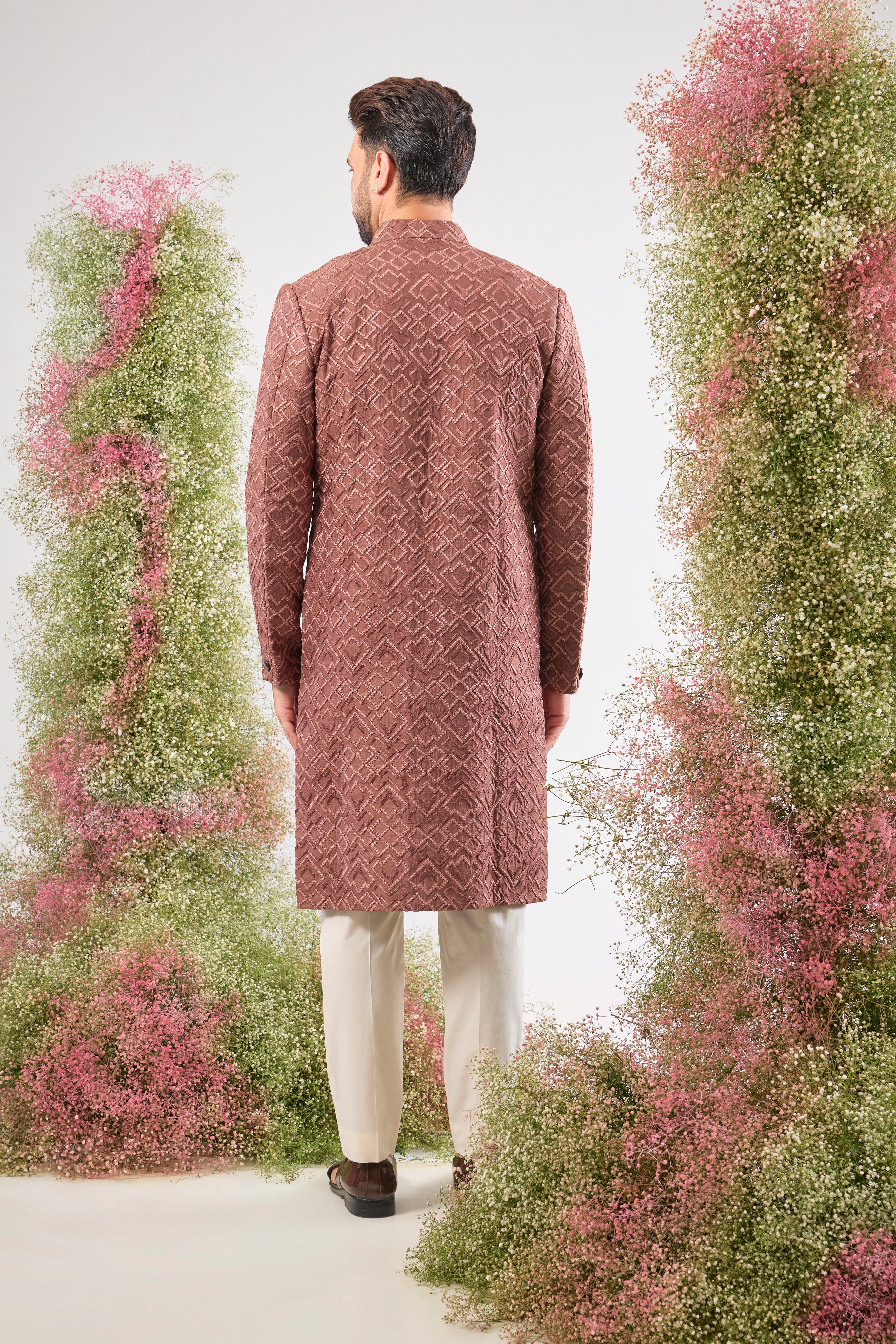 This Mauve Taupe Sherwani is a masterpiece of design, showcasing intense Heavy Thread Work in a mesmerizing Geometrical Pattern across the luxurious silk fabric.