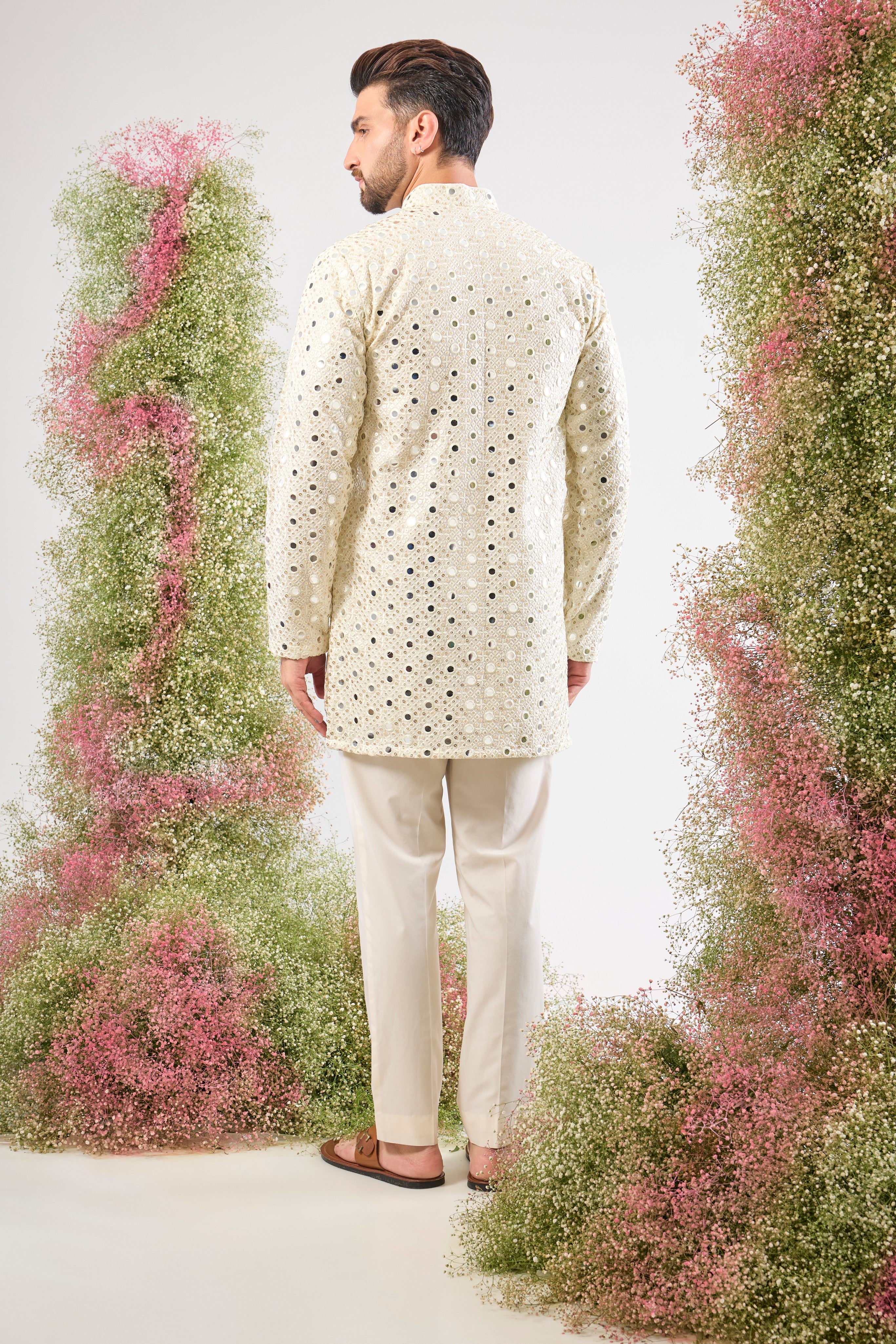 his White Short Mirror Work Kurta showcases the weight and brilliance of Detailed Heavy Sequin Work, providing a richly textured, luminous surface. The pristine white colour enhances the sparkle, ensuring a truly show-stopping look