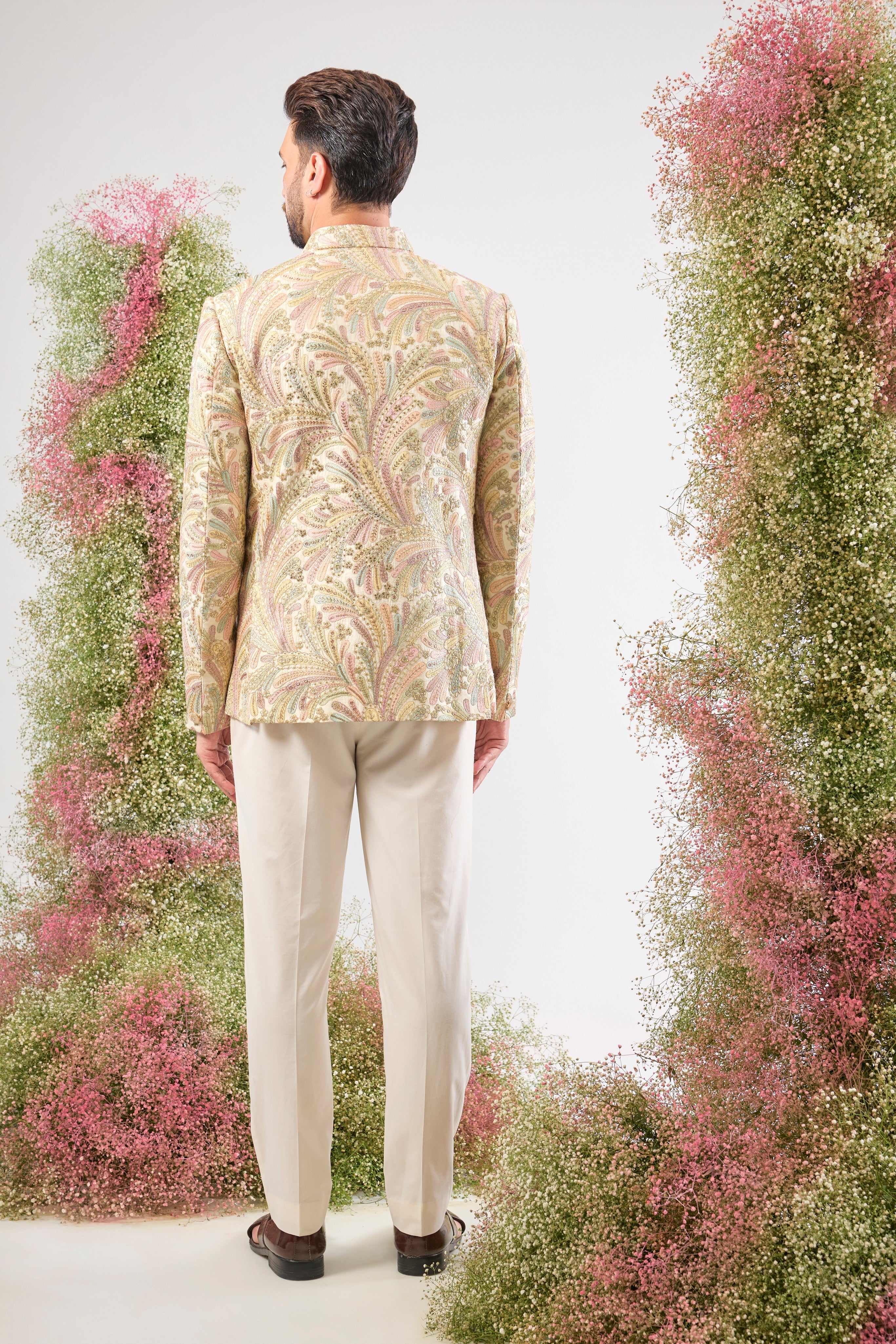 This Multi-coloured Floral Bandhgala beautifully combines intricate Floral Embroidery and rich Multi-thread Work. The design is elevated by subtle Zari Touches and Sequins for a festive sparkle, while White Metal Buttons provide a clean, elegant finish