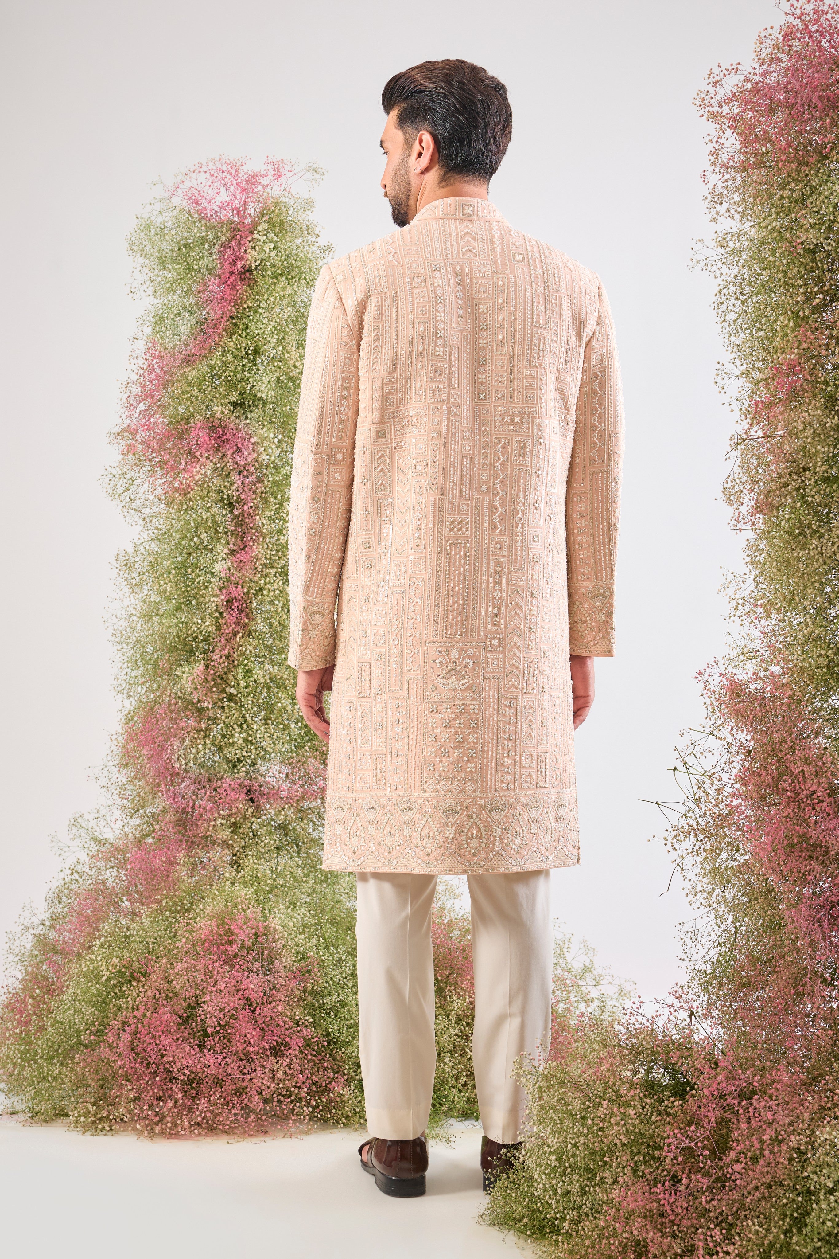 This Pink Sherwani showcases beautiful Geometrical Embroidery, with every line and angle accentuated by dazzling Cut Dana, reflective Sequins, and rich Zari Touches.